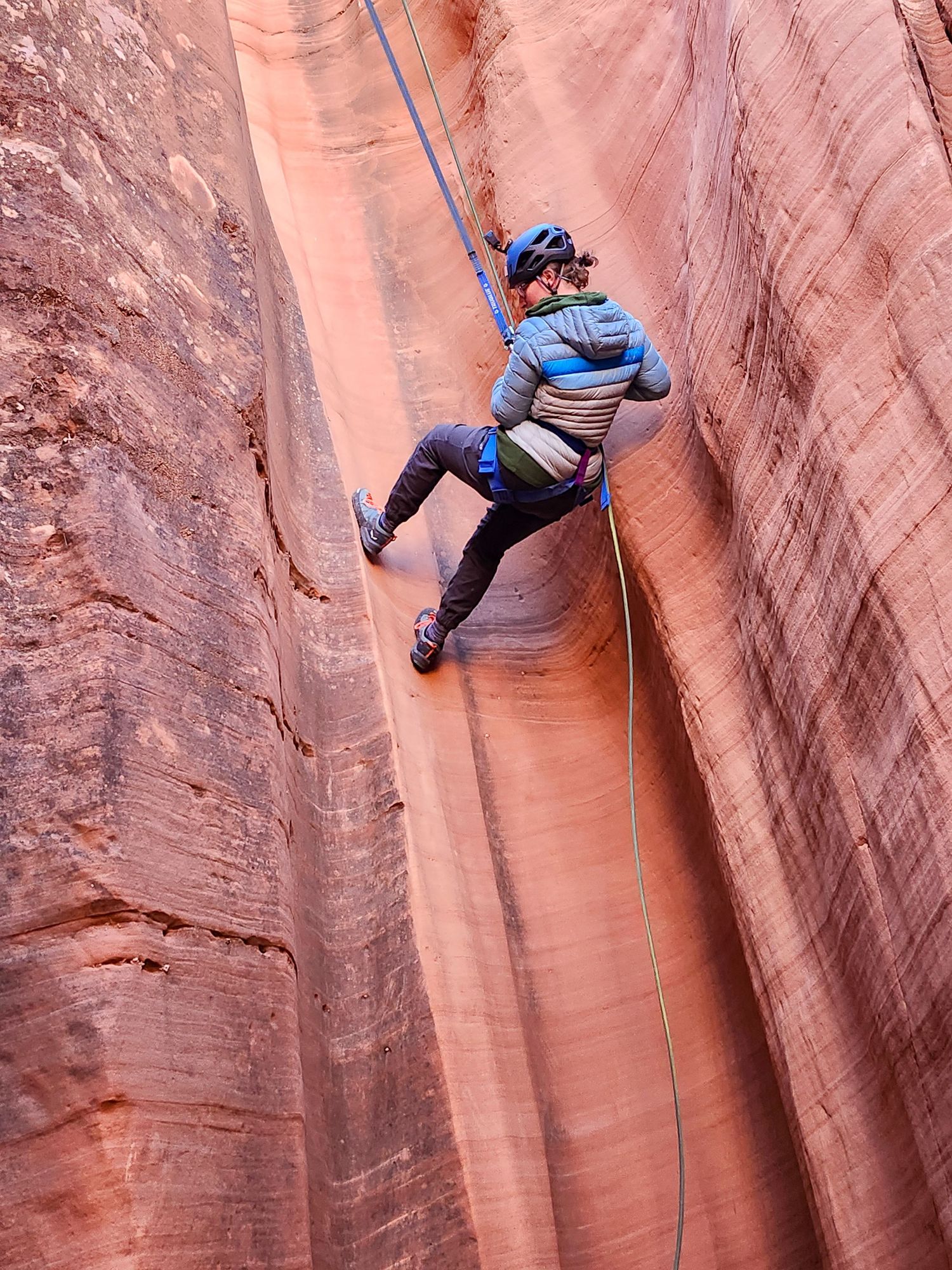 Canyoneering and rappelling in sandstone cliff walls in Utah
