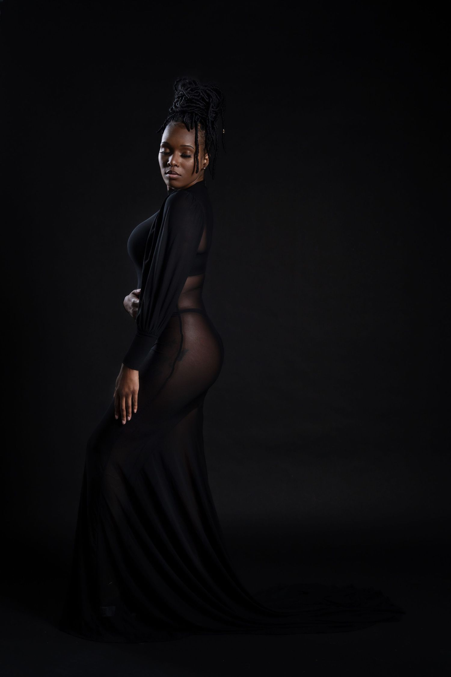 Elegant fashion portrait in sheer black dress with dramatic lighting and pose in Saint Petersburg Florida.