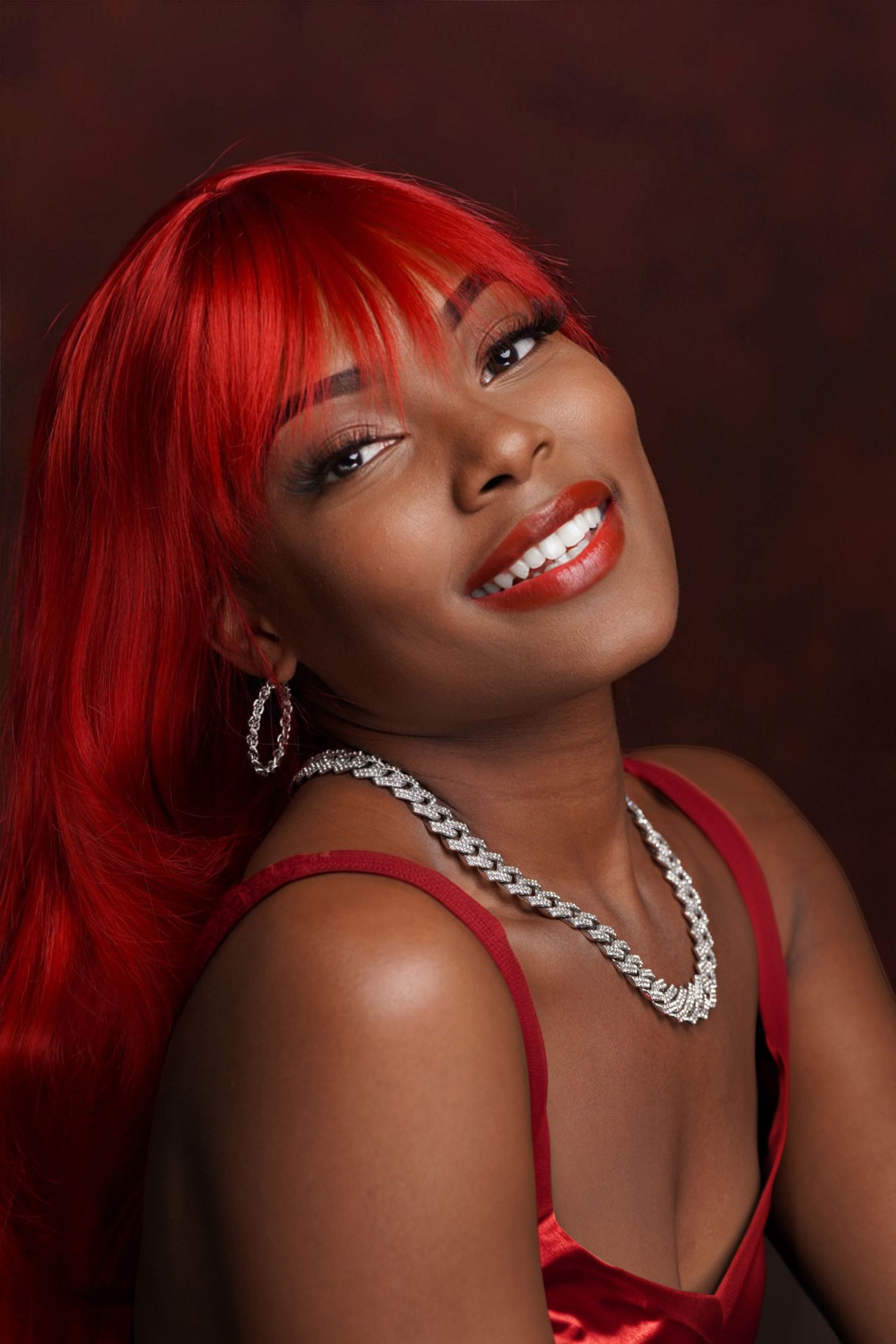 Glamour portrait featuring bright red hair and silver statement necklace against dark background in Saint Petersburg Florida.
