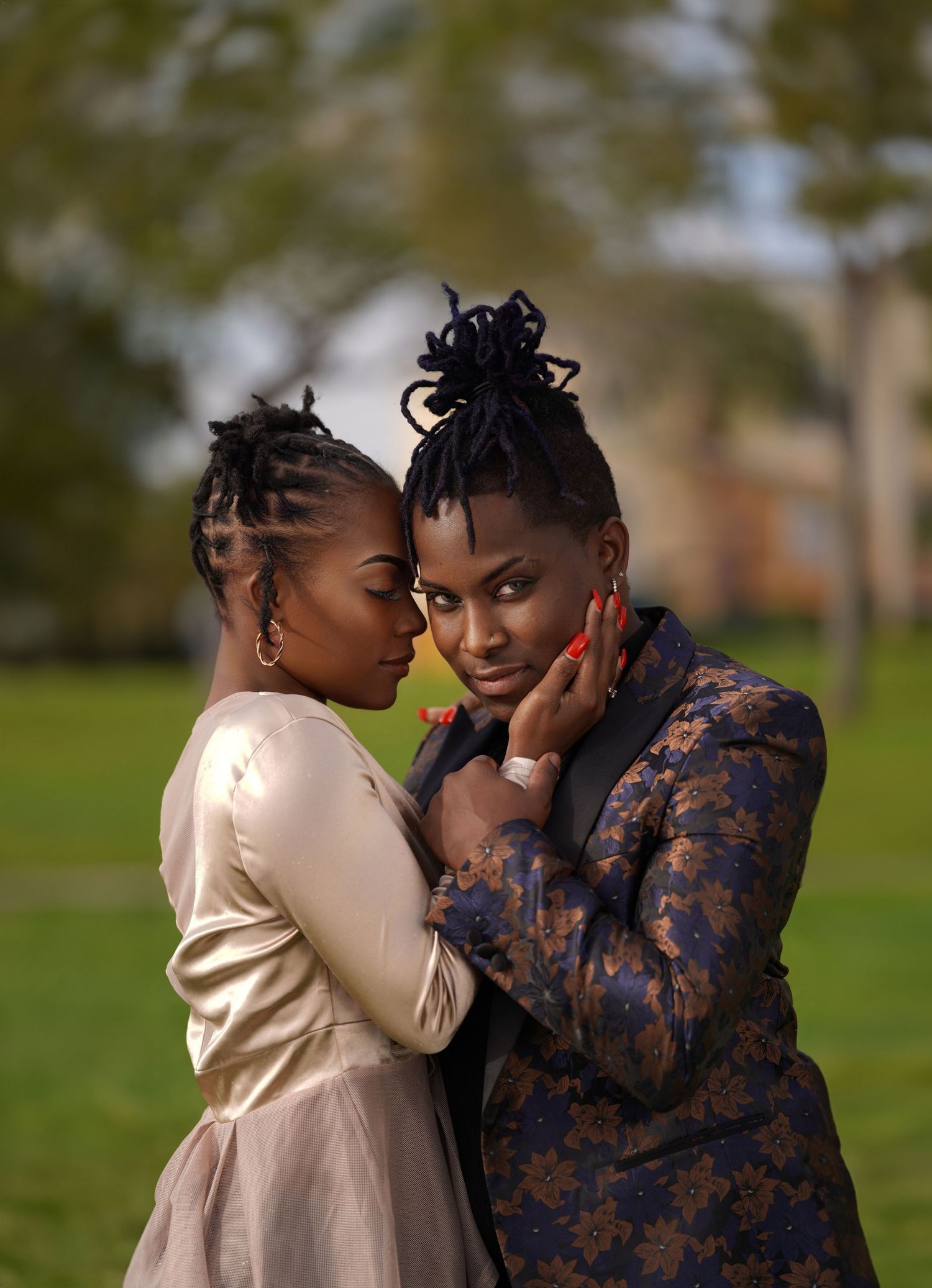 Intimate outdoor photo session with two people in contrasting outfits sharing tender moments.