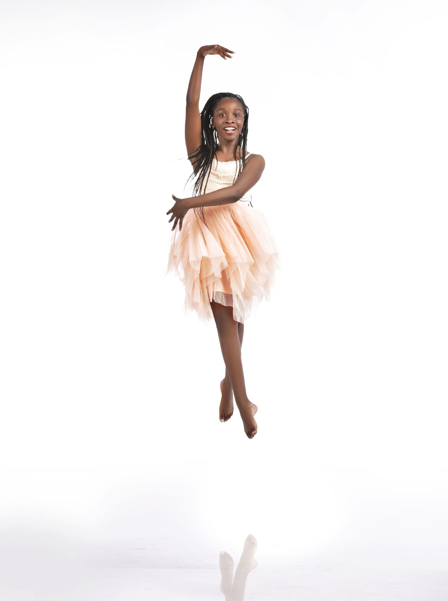 Young dancer in pink tutu performing graceful poses against white backdrop in Saint Petersburg Florida.