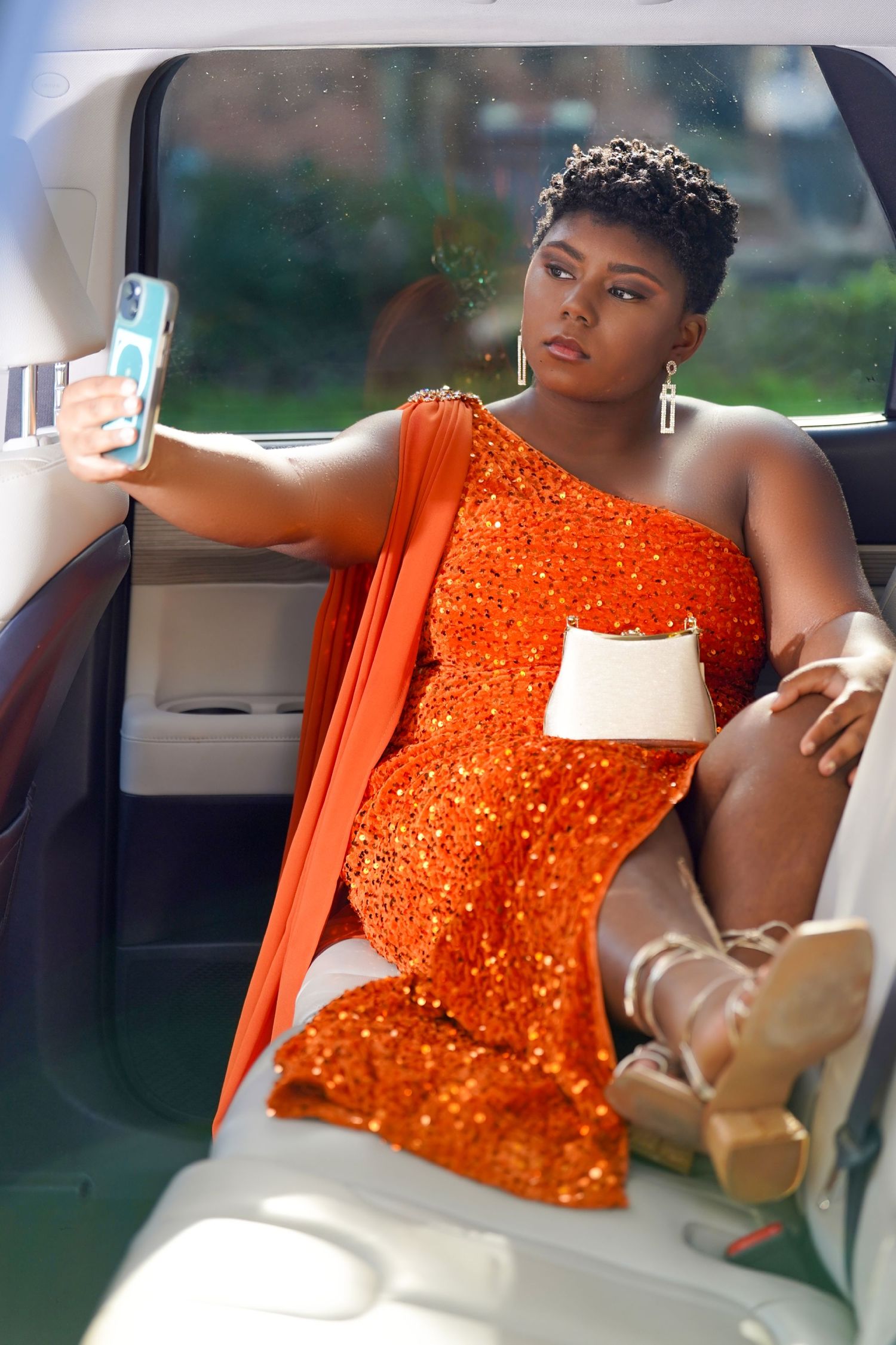Luxury car photoshoot featuring an orange sequined dress in the back seat in Tampa Florida.