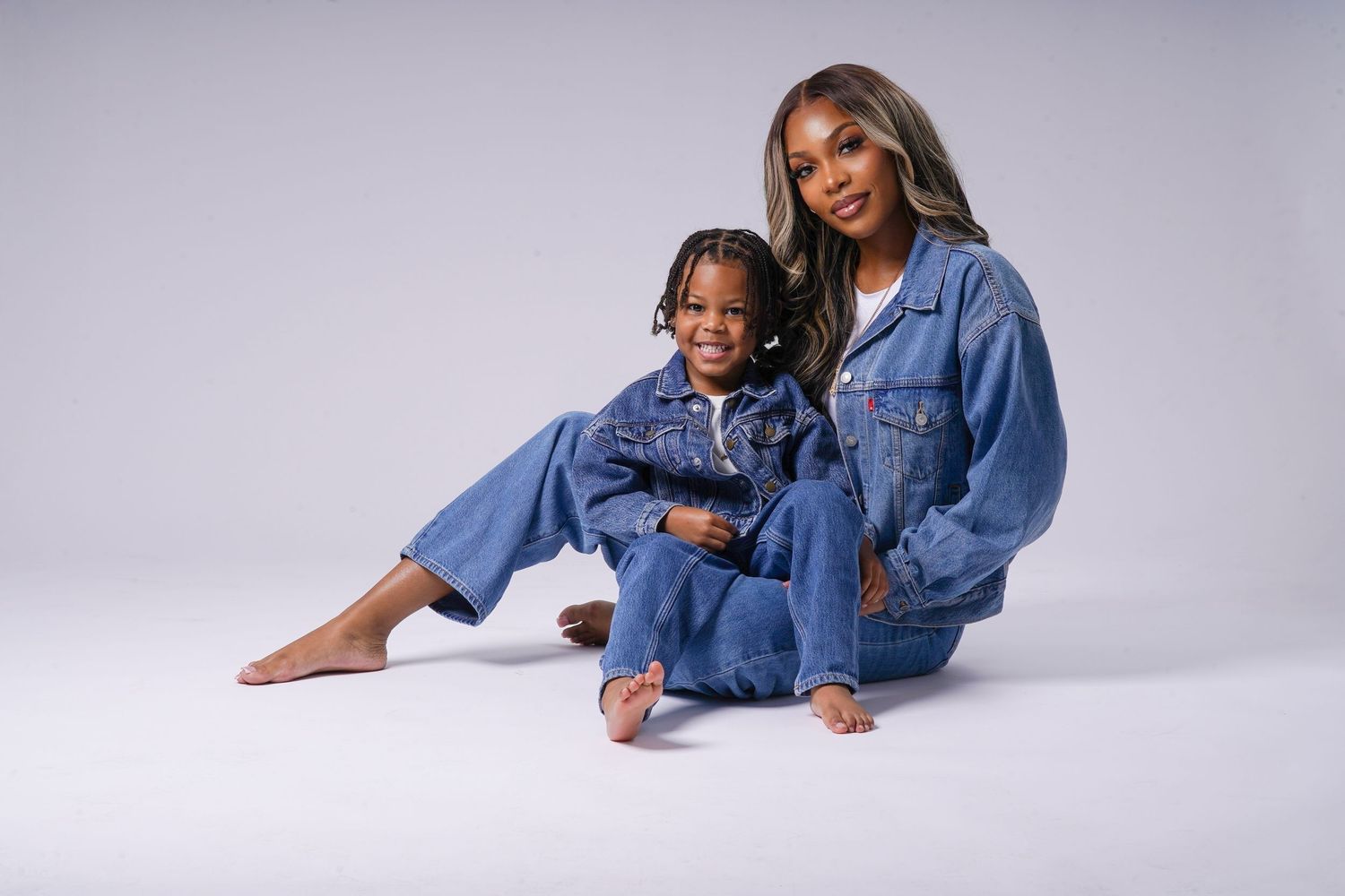 Studio fashion shoot featuring mom and son in casual denim outfits against grey background in Saint Petersburg Florida.