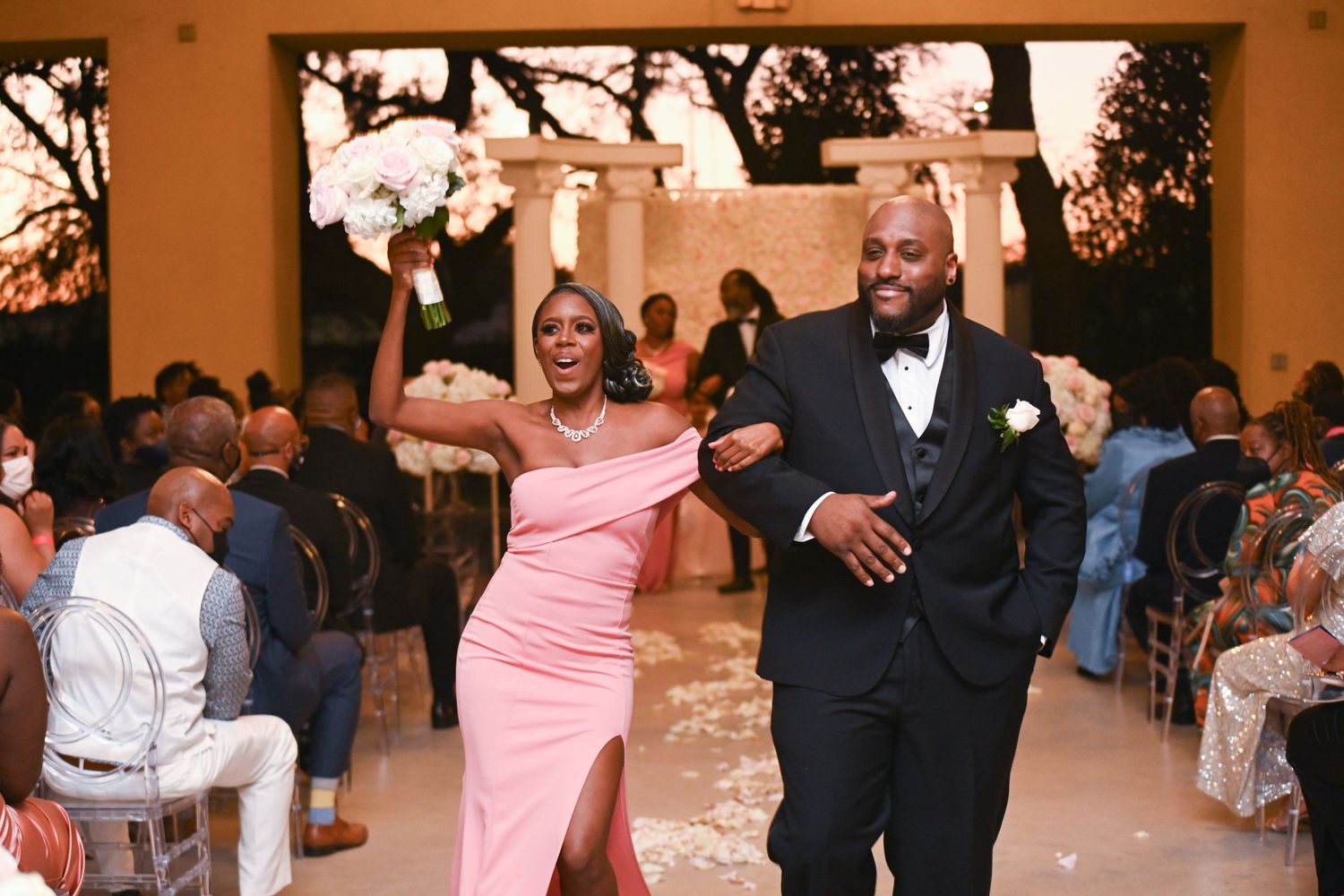 Wedding reception celebration with guests dancing in formal attire.