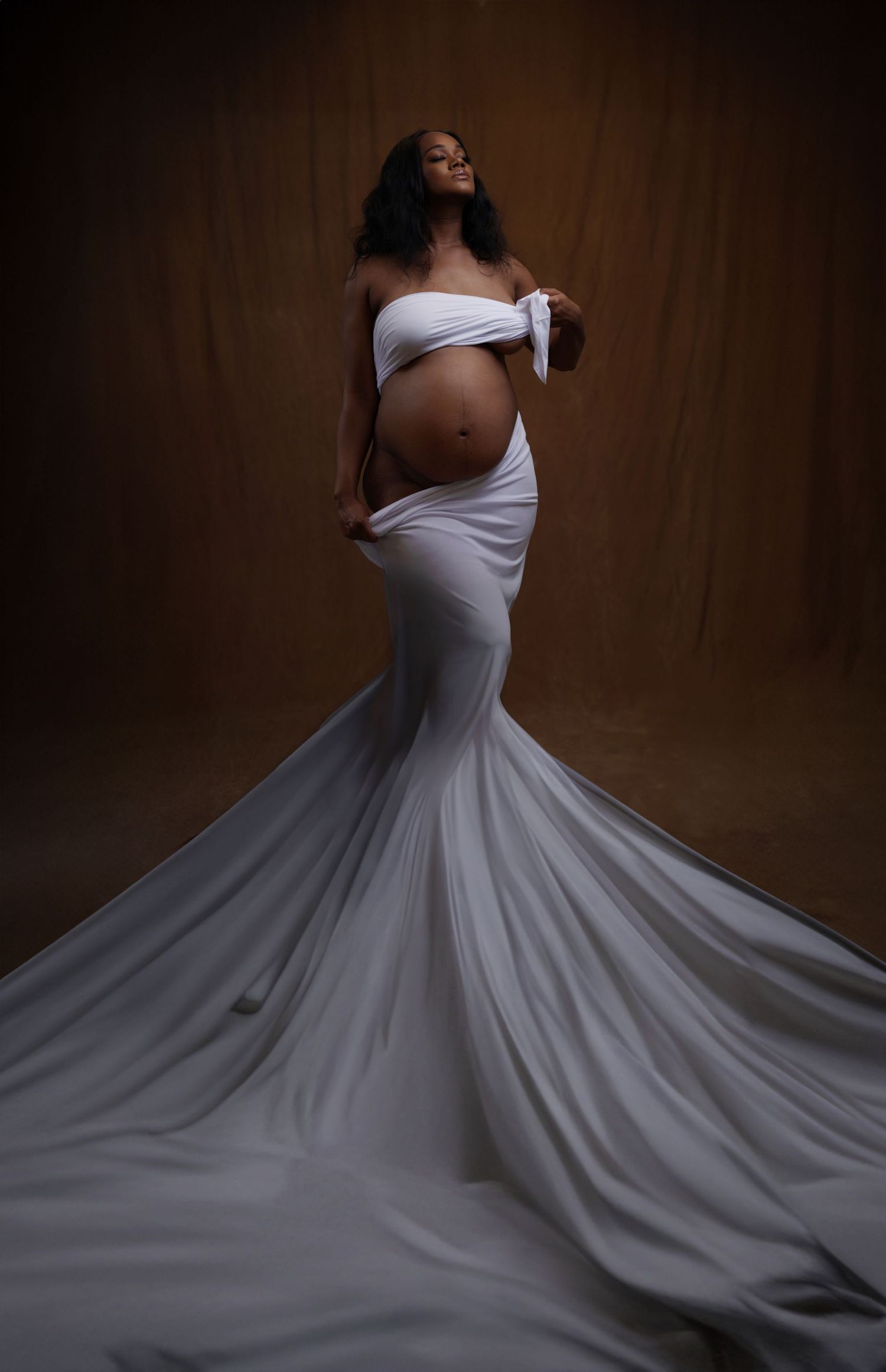 Dramatic portraits of flowing white dress against dark wooden background in Saint Petersburg Florida.