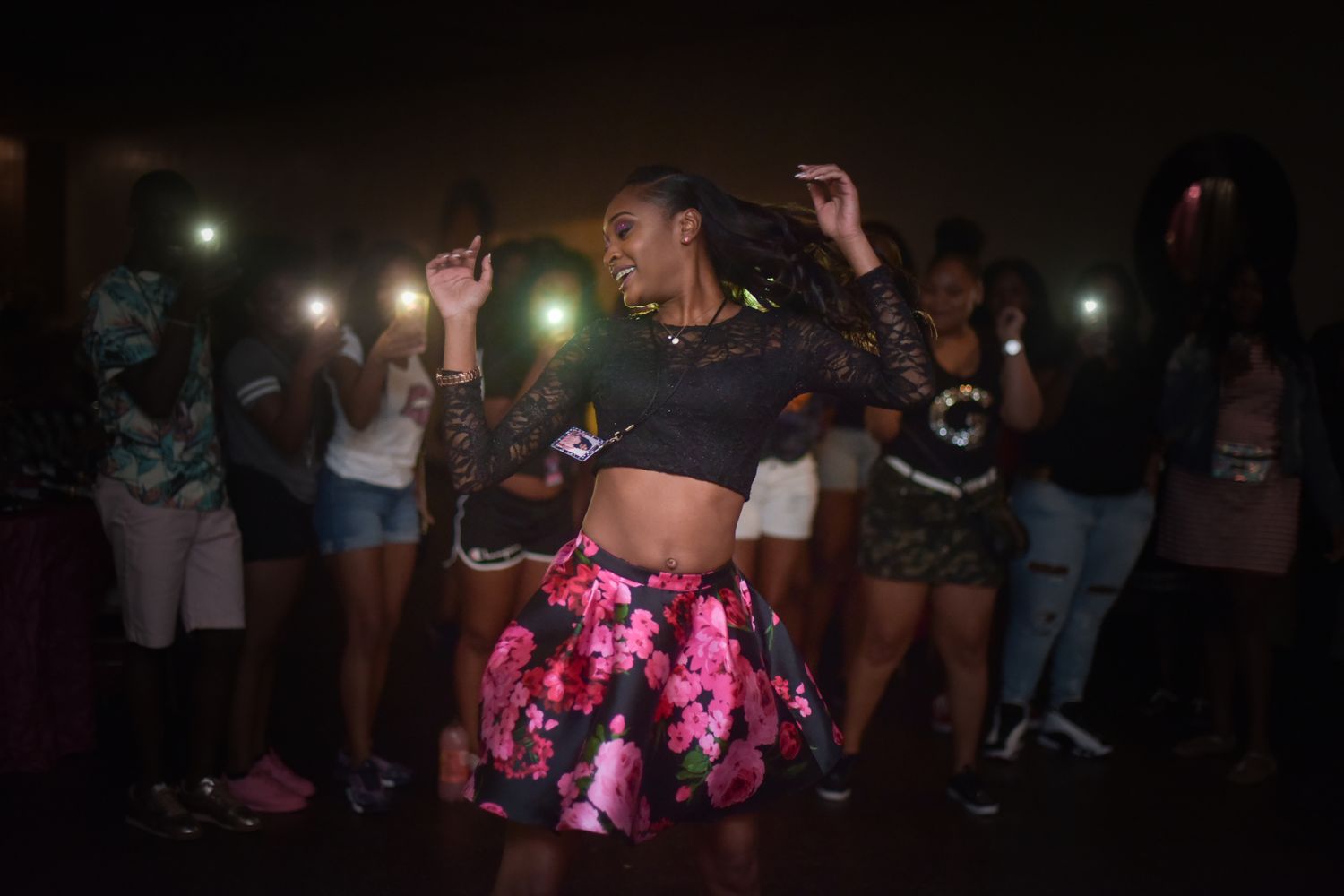 People dancing and enjoying themselves at a dimly lit nightclub with colorful lighting effects.