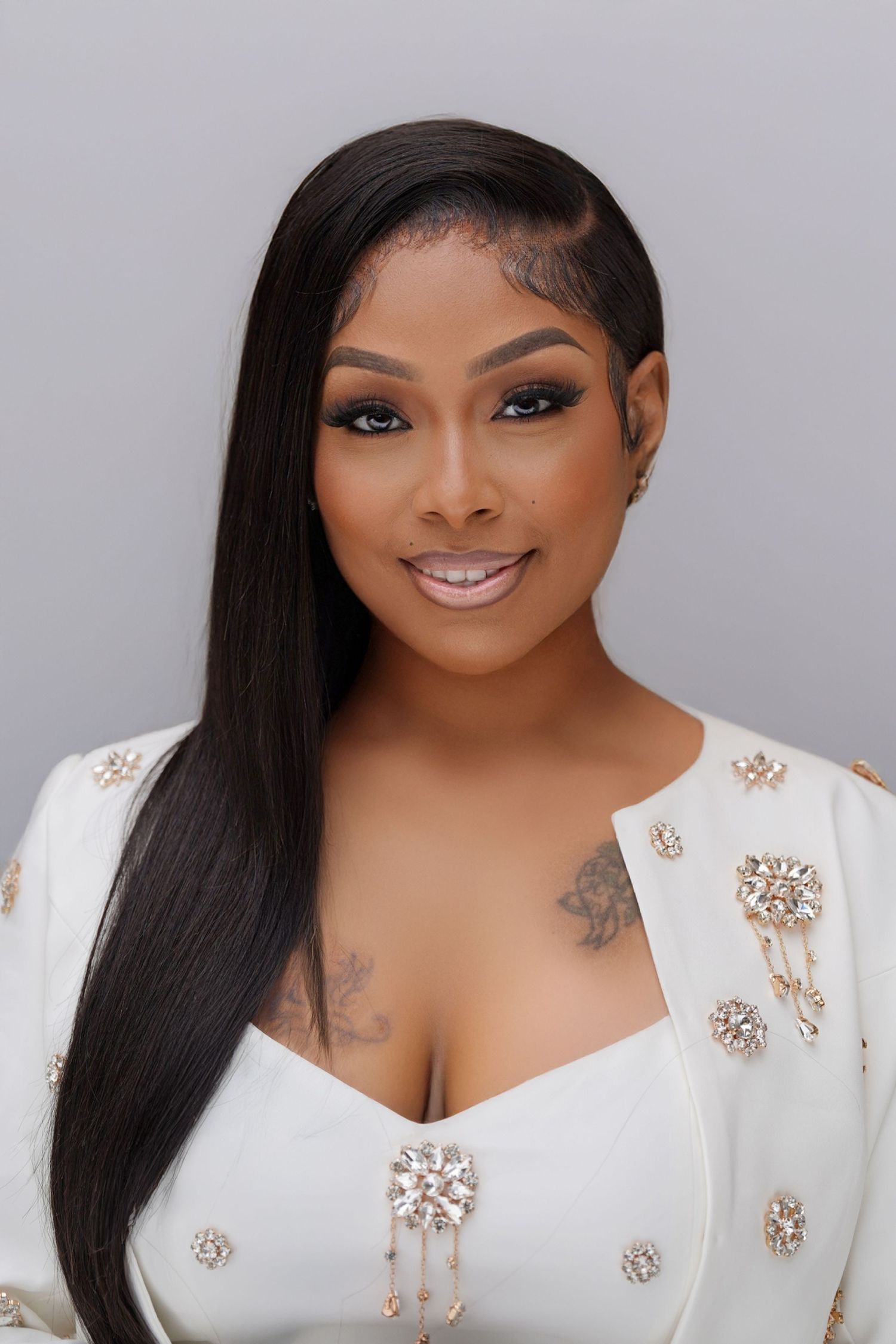 Glamour beauty portrait with sleek hair and white embellished top against grey background in Saint Petersburg Florida.