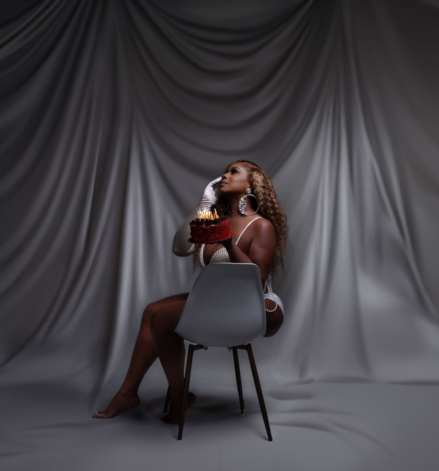 Artistic photoshoot with grey backdrop and modern chair creating minimalist studio composition in Saint Petersburg Florida.