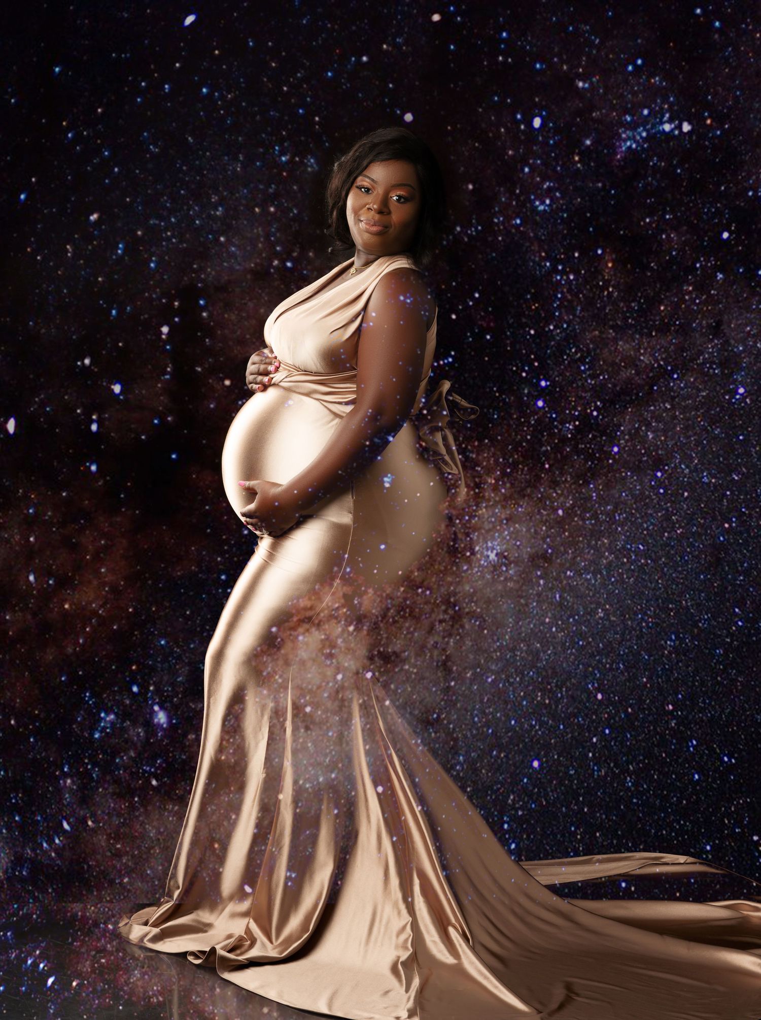Ethereal maternity portrait against a starry night sky background with flowing champagne gown.