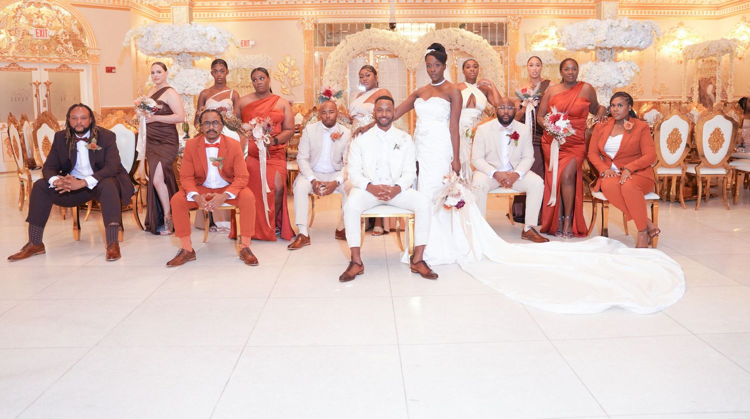 Wedding reception venue with guests seated in formal attire under warm lighting.
