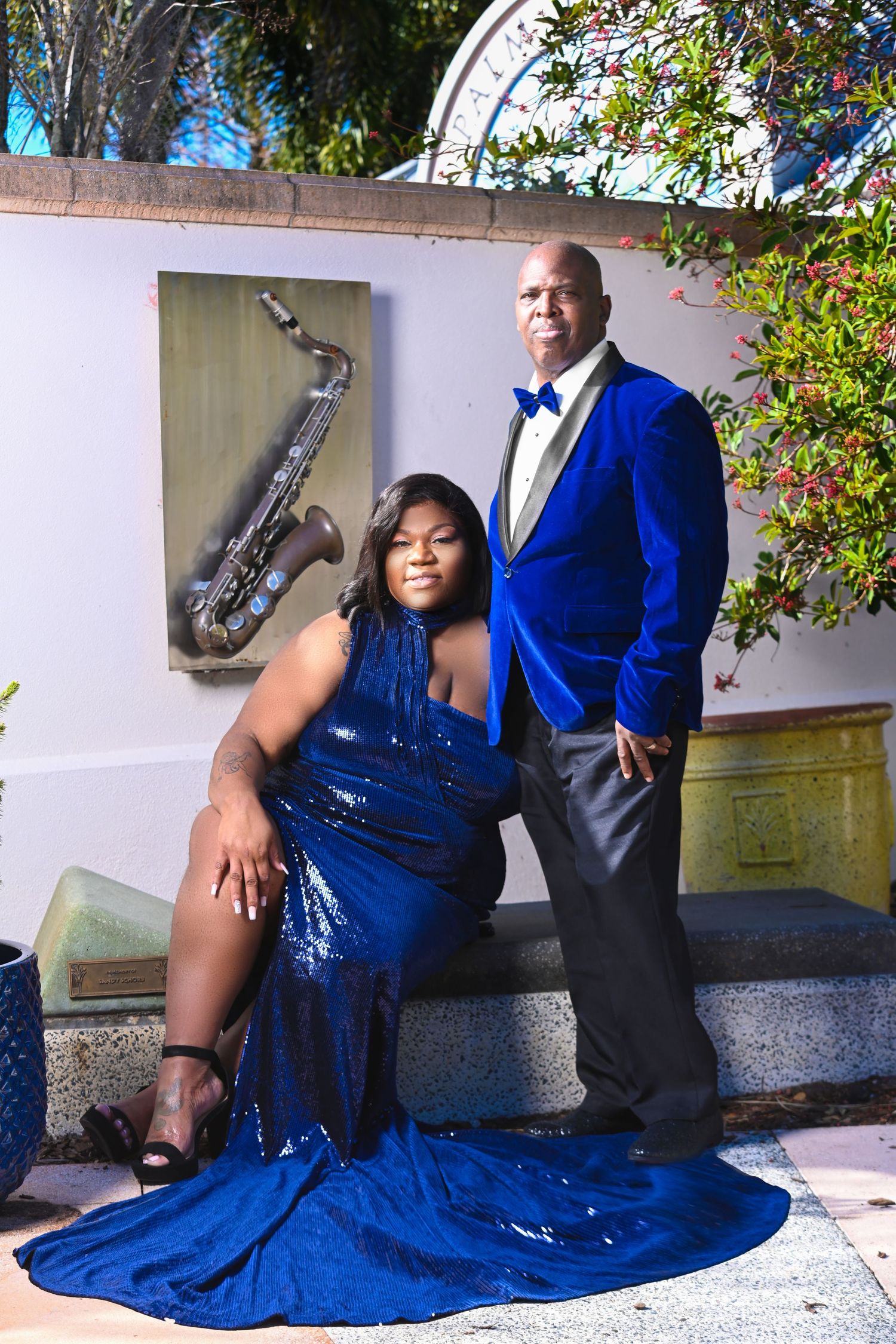Tampa Florida Formal portrait session with blue sequin gown and saxophone prop against outdoor backdrop.