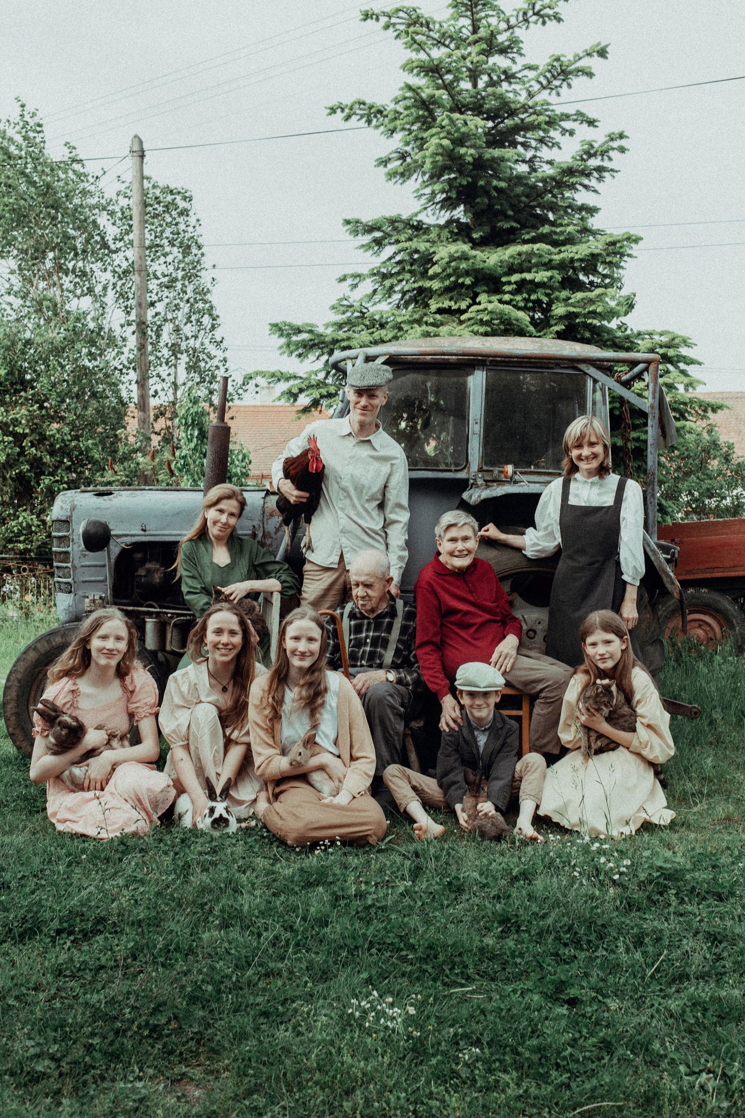 A group of people relaxing together on a grassy hillside on a summer day.