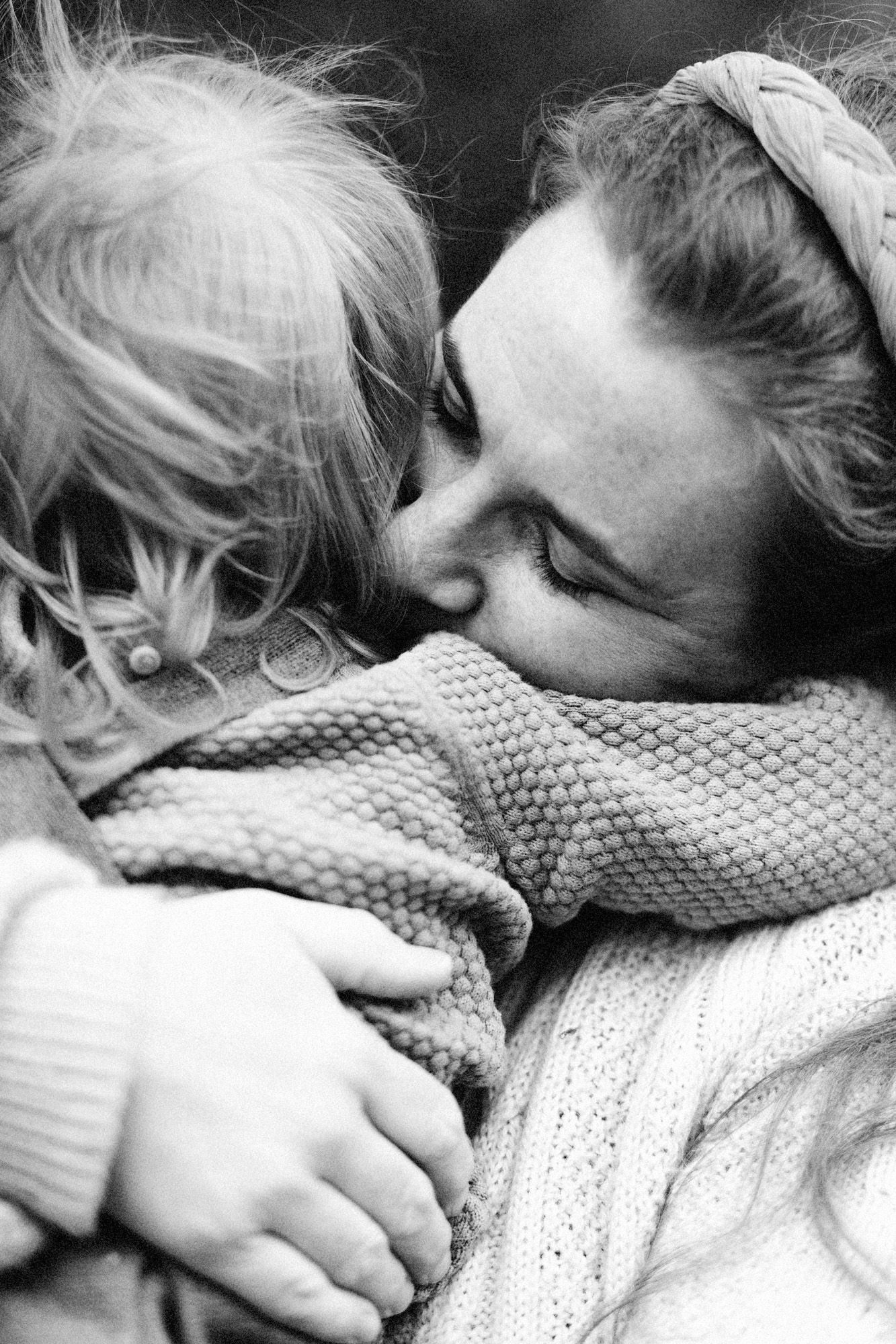 A tender black and white moment captured between two people in warm sweaters.
