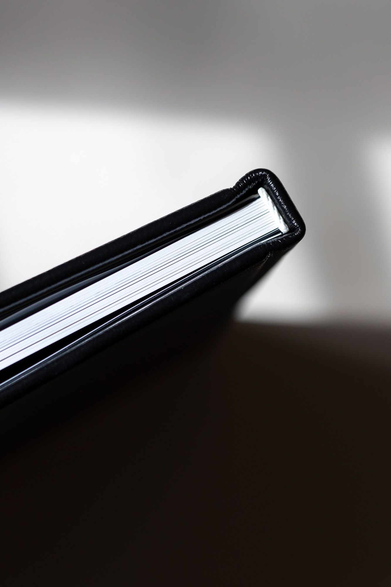 Close-up view of a book spine showing pages fanned out against a dark background with dramatic lighting.
