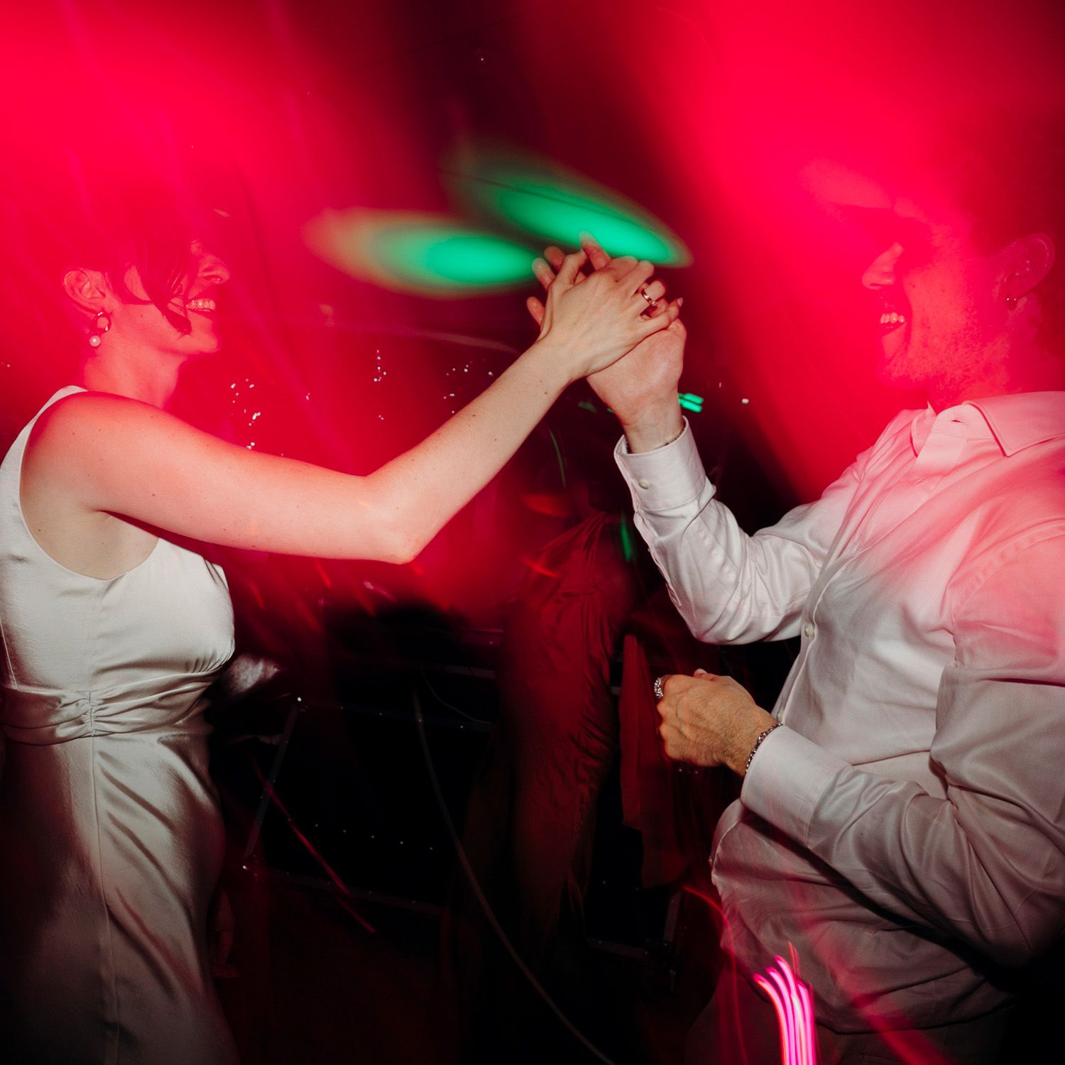 A person in white clothing dancing against a vibrant red background with dramatic motion blur effects.
