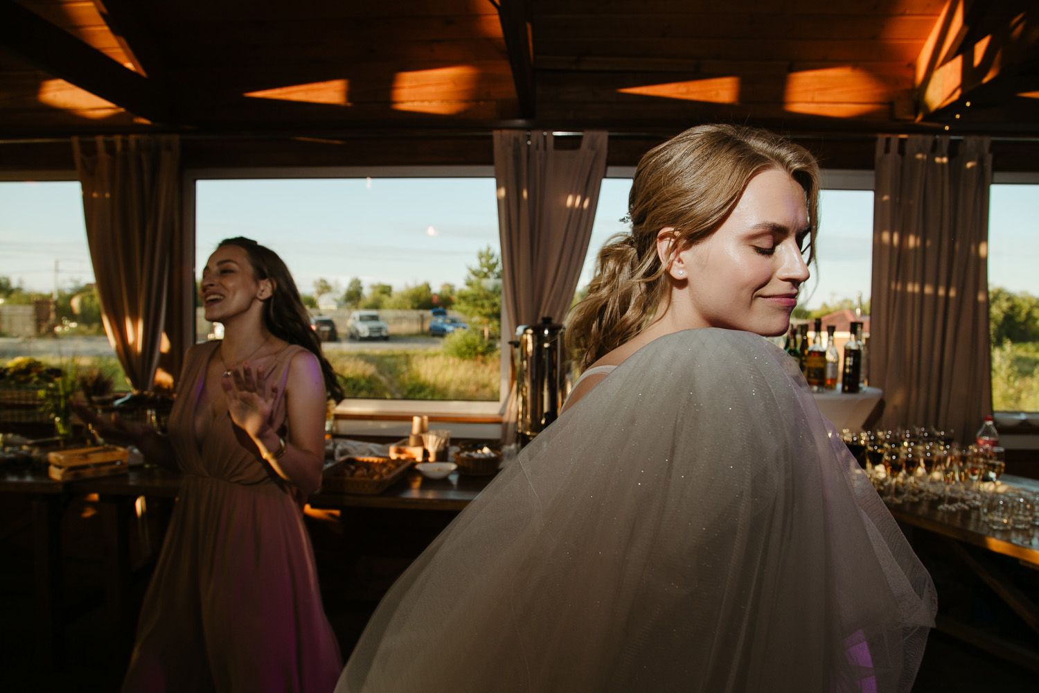 Rustic indoor wedding venue with wooden beams and natural lighting streaming through windows.