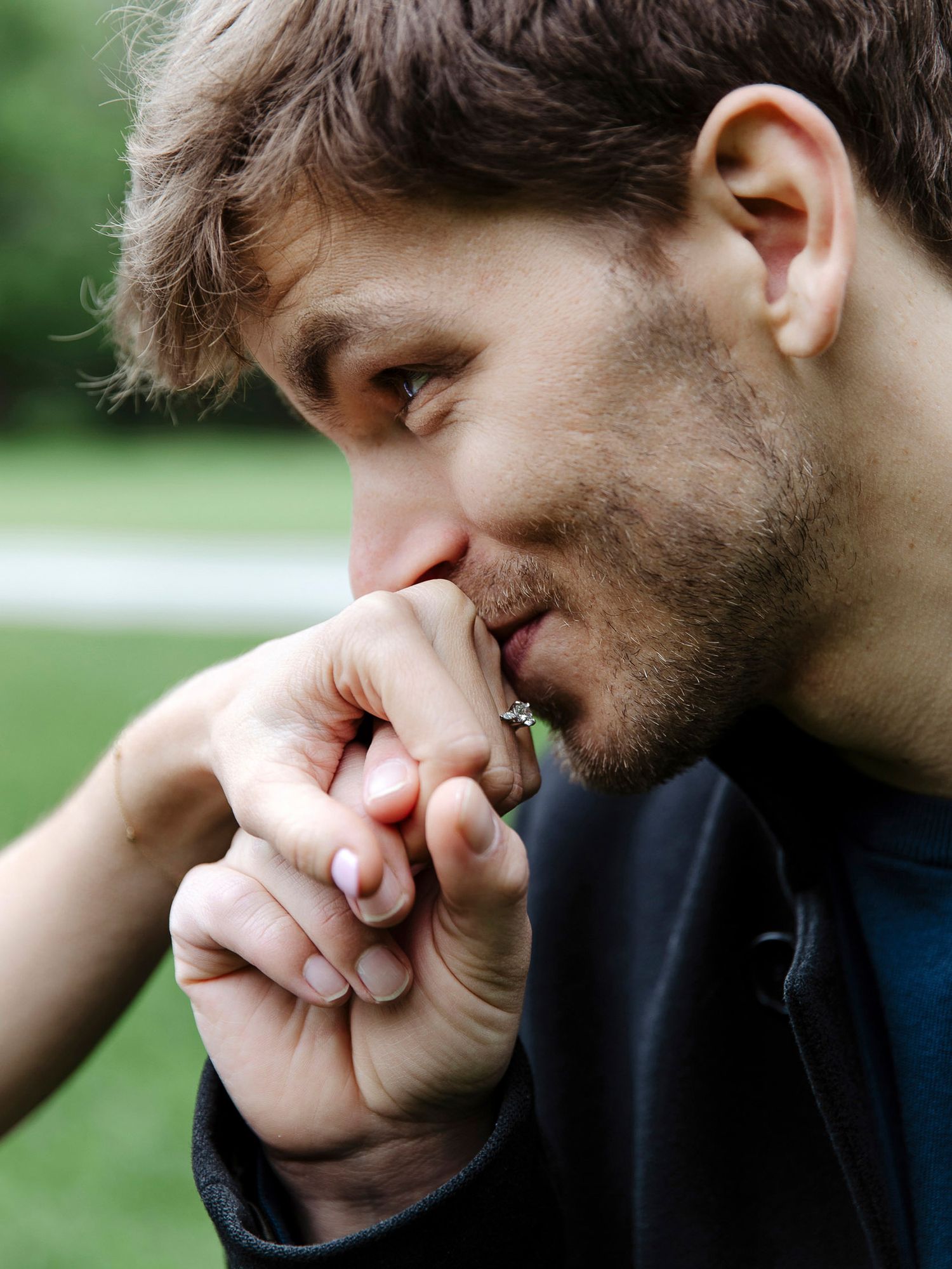 A person in a black shirt rests their head against their hand while looking down in a series of contemplative poses.