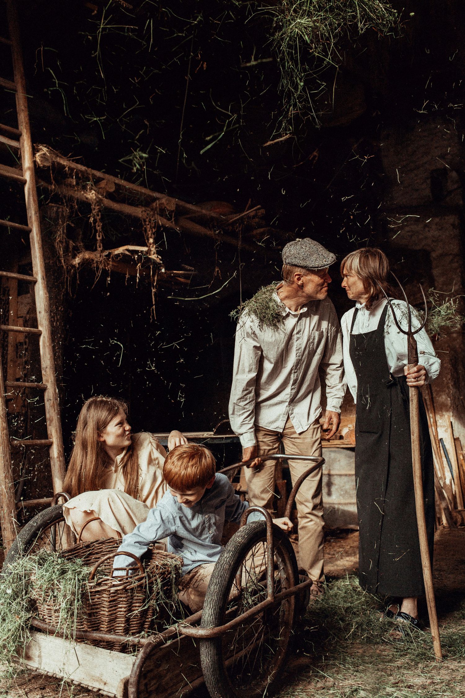 Vintage-style family scene with rustic baskets and wooden shelter in forest setting.
