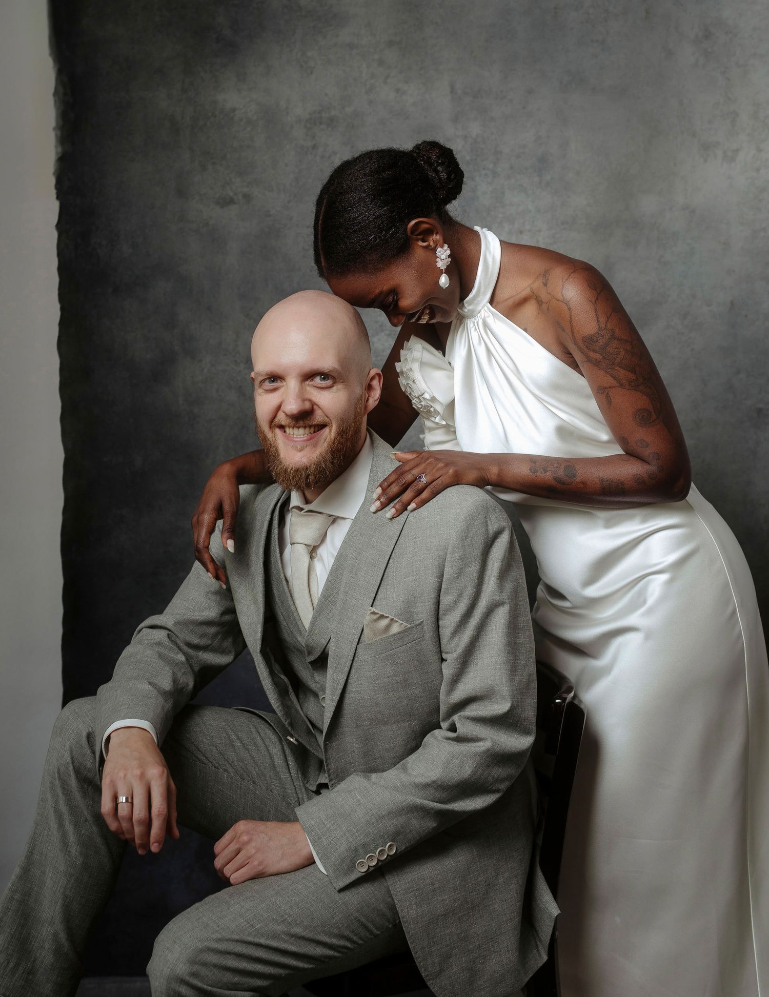 Artistic portrait series showing tender moments between two people in gray tones against a dark backdrop.