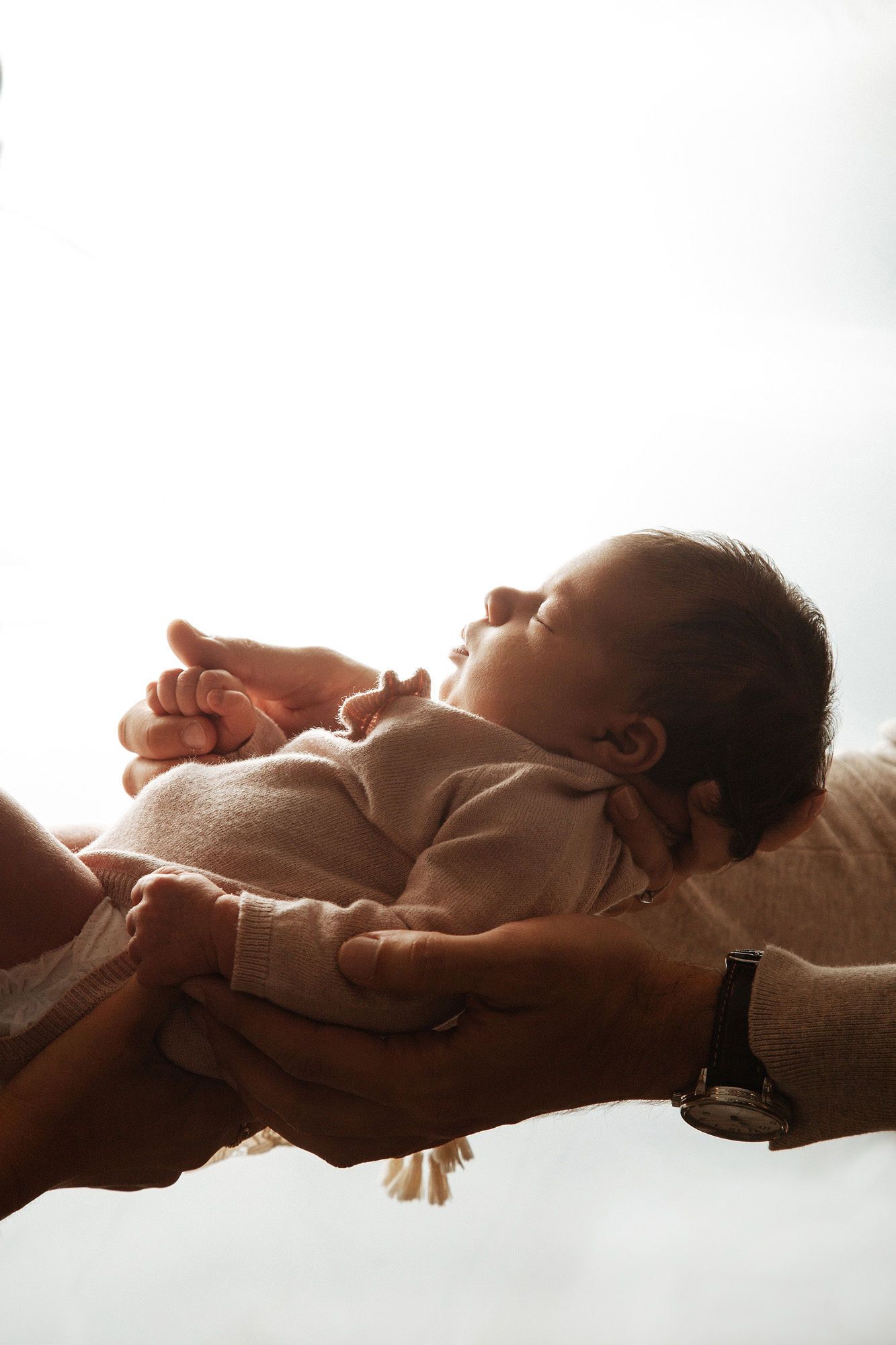 Silhouetted baby lying down in soft natural window light creating a peaceful and dreamy atmosphere.