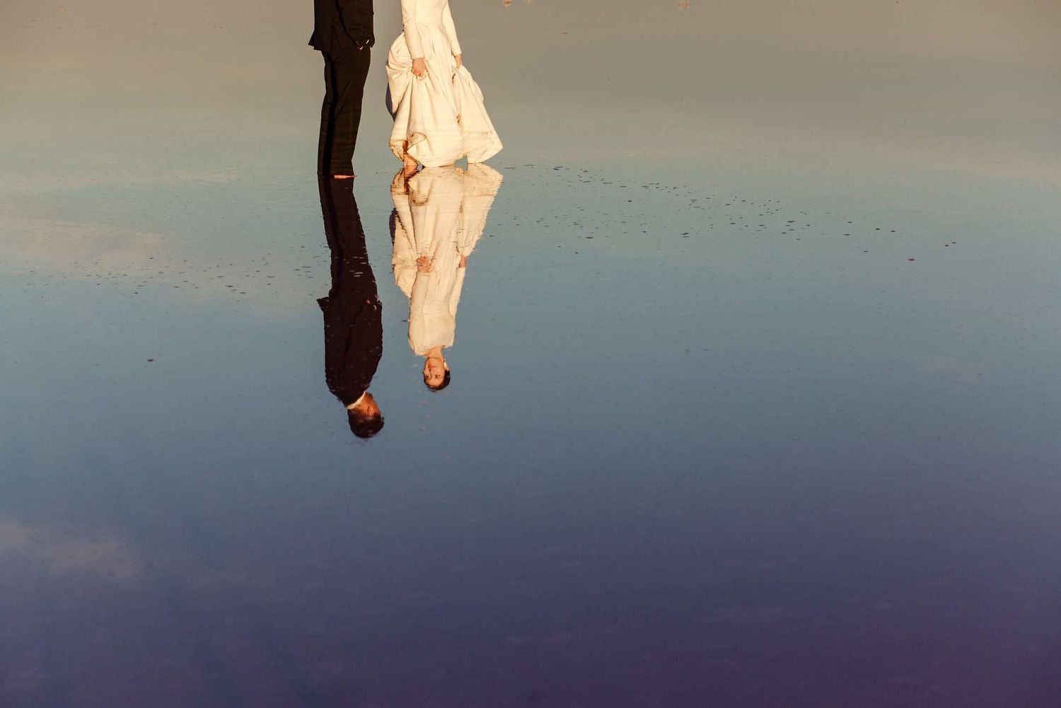Silhouetted figure against a gradient blue sky during sunset or sunrise.