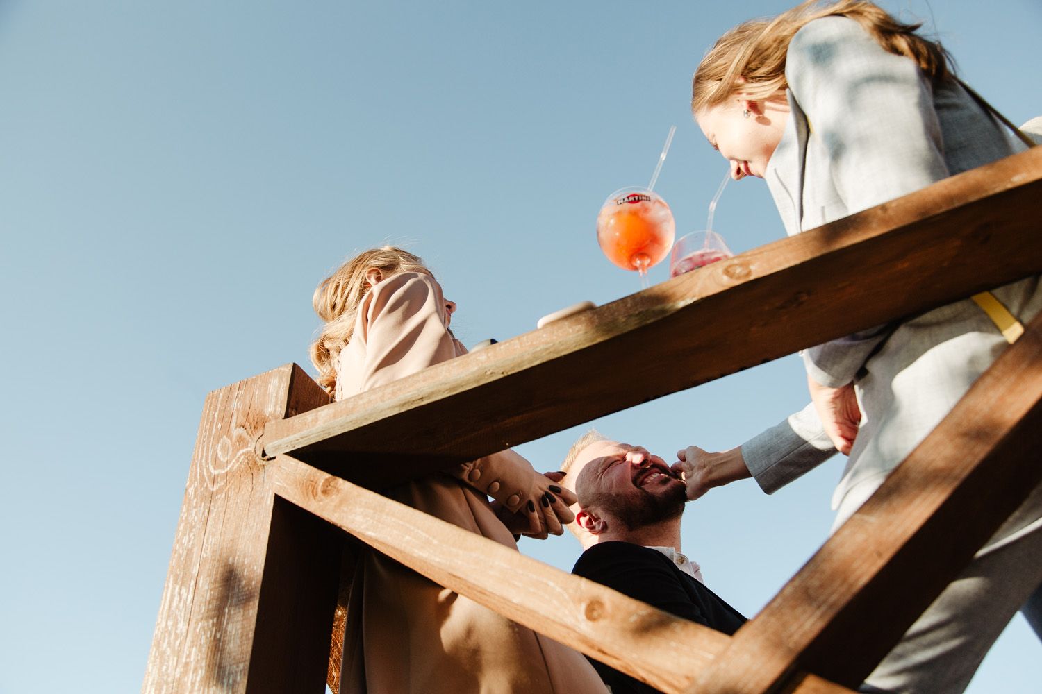 Wedding celebration on rustic outdoor wooden deck with drinks and celebration.