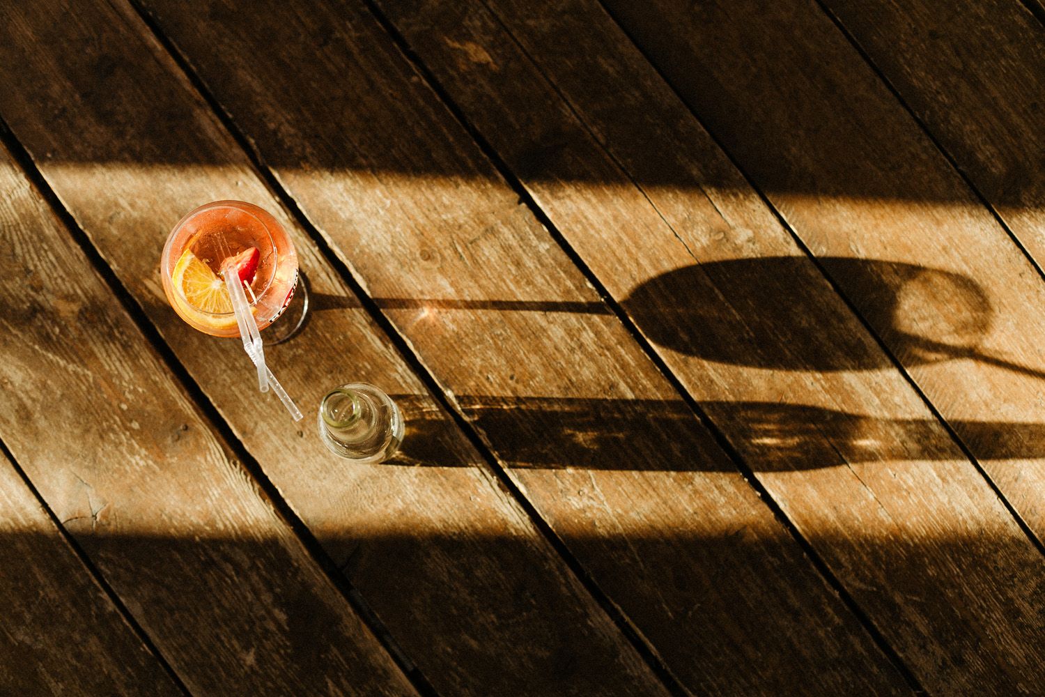 Wooden deck floor with dramatic shadows and lighting effects.