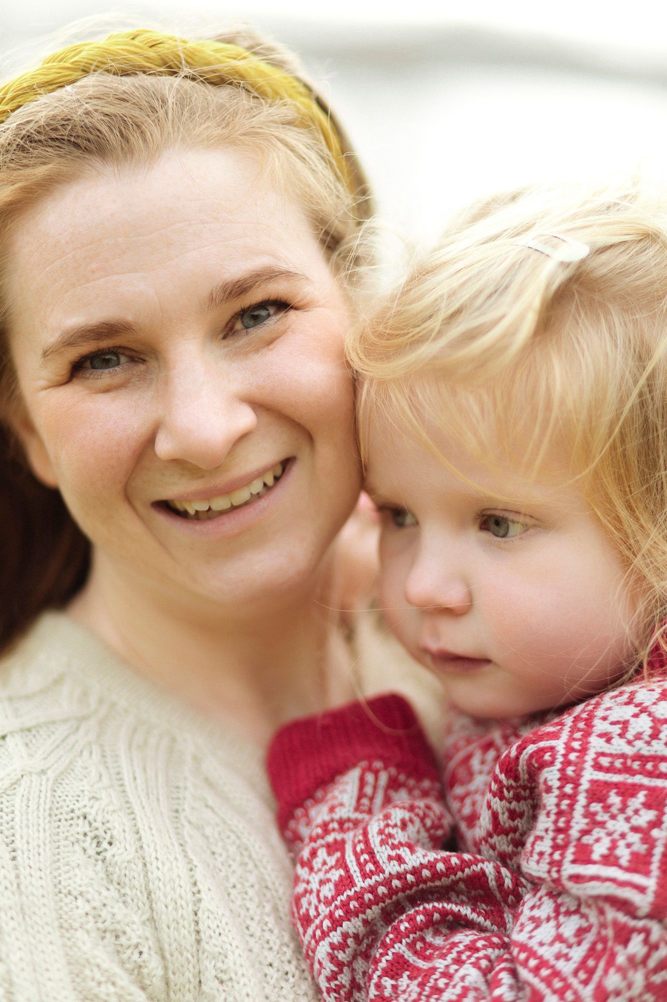 A heartwarming portrait of parent and child wearing cozy winter sweaters.