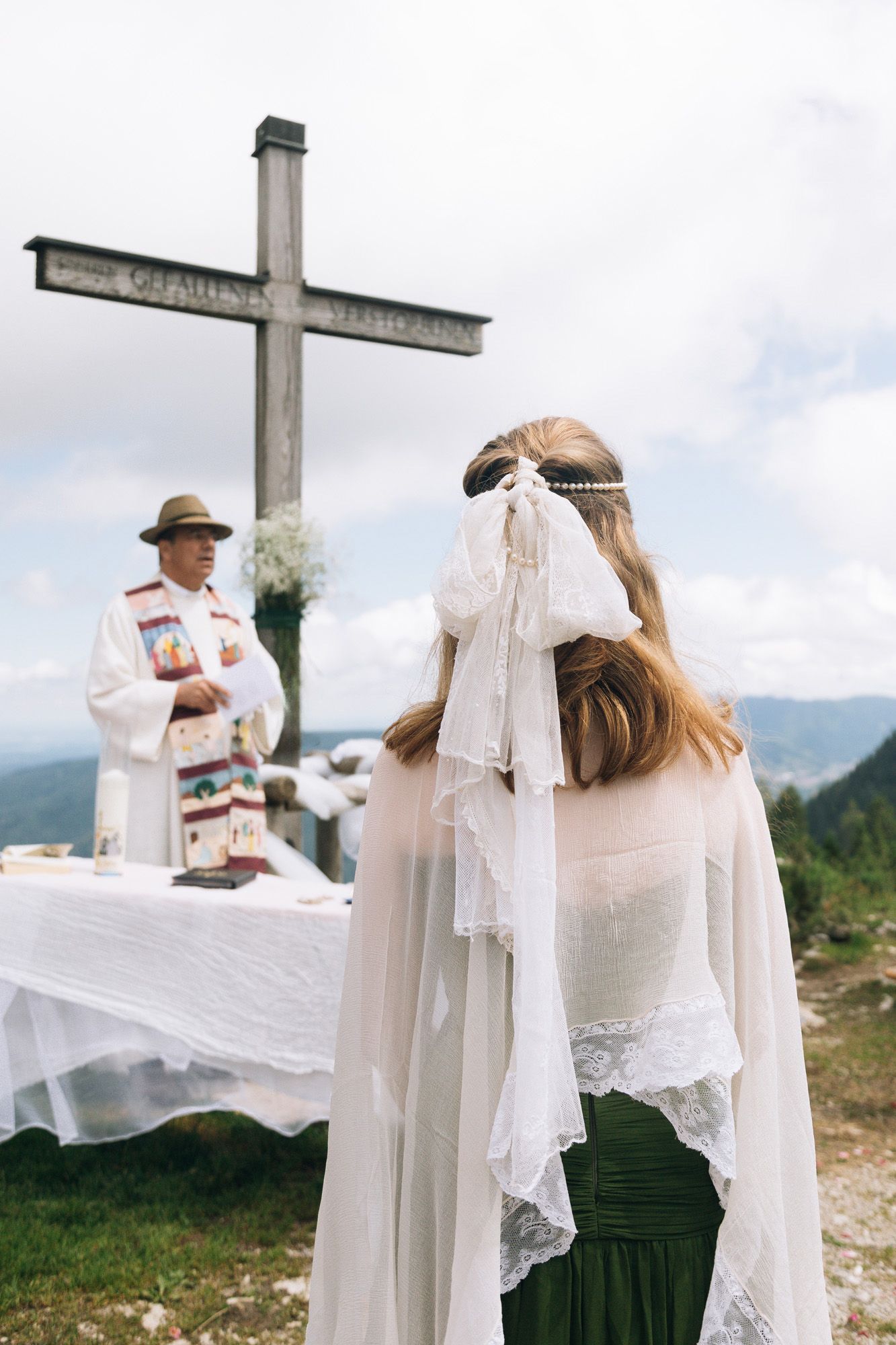 A series of four photos showing white fabric flowing in the wind against a mountain landscape backdrop.