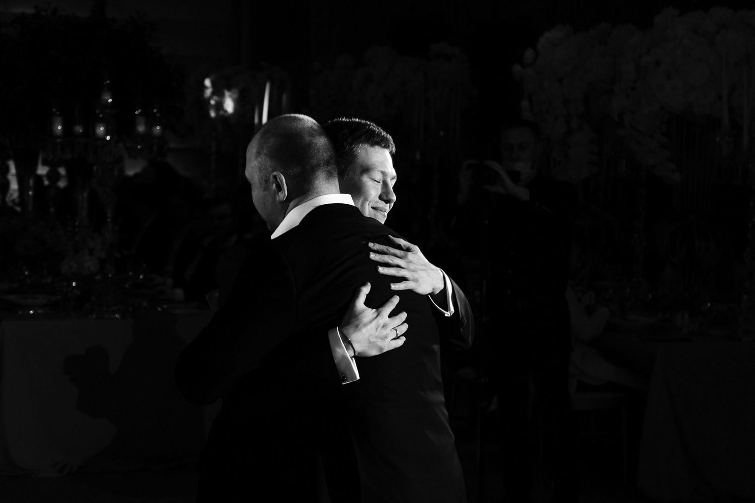 Two people dance gracefully in silhouette against a dark background during a performance.