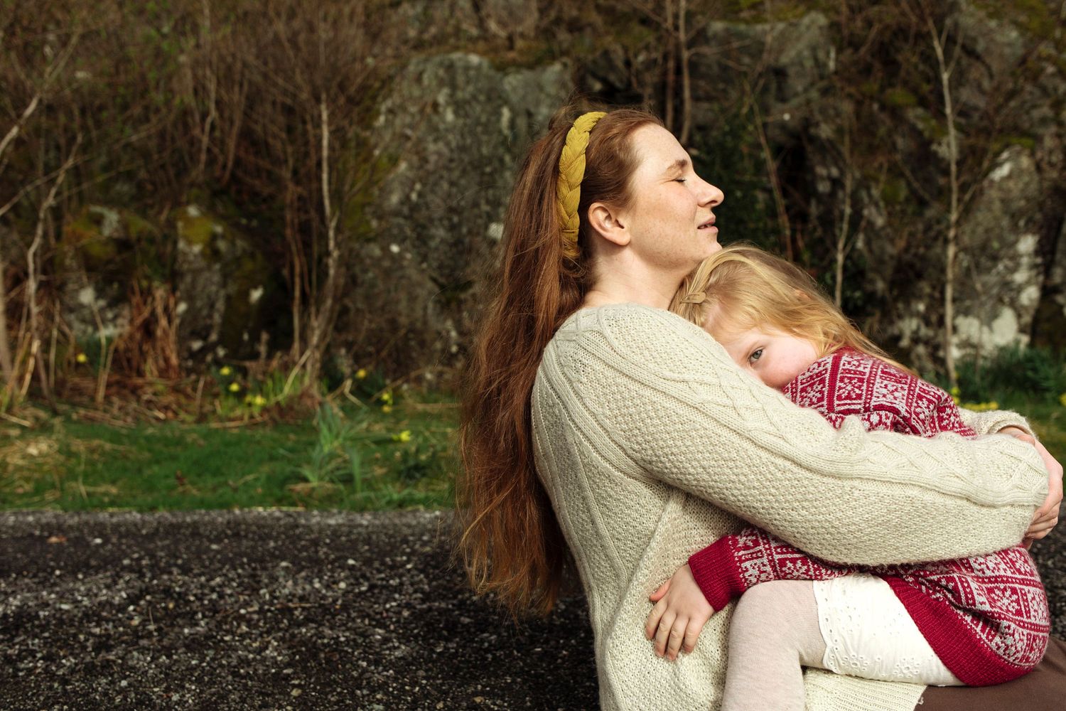 A serene moment of rest against a rocky backdrop in warm knit sweaters.
