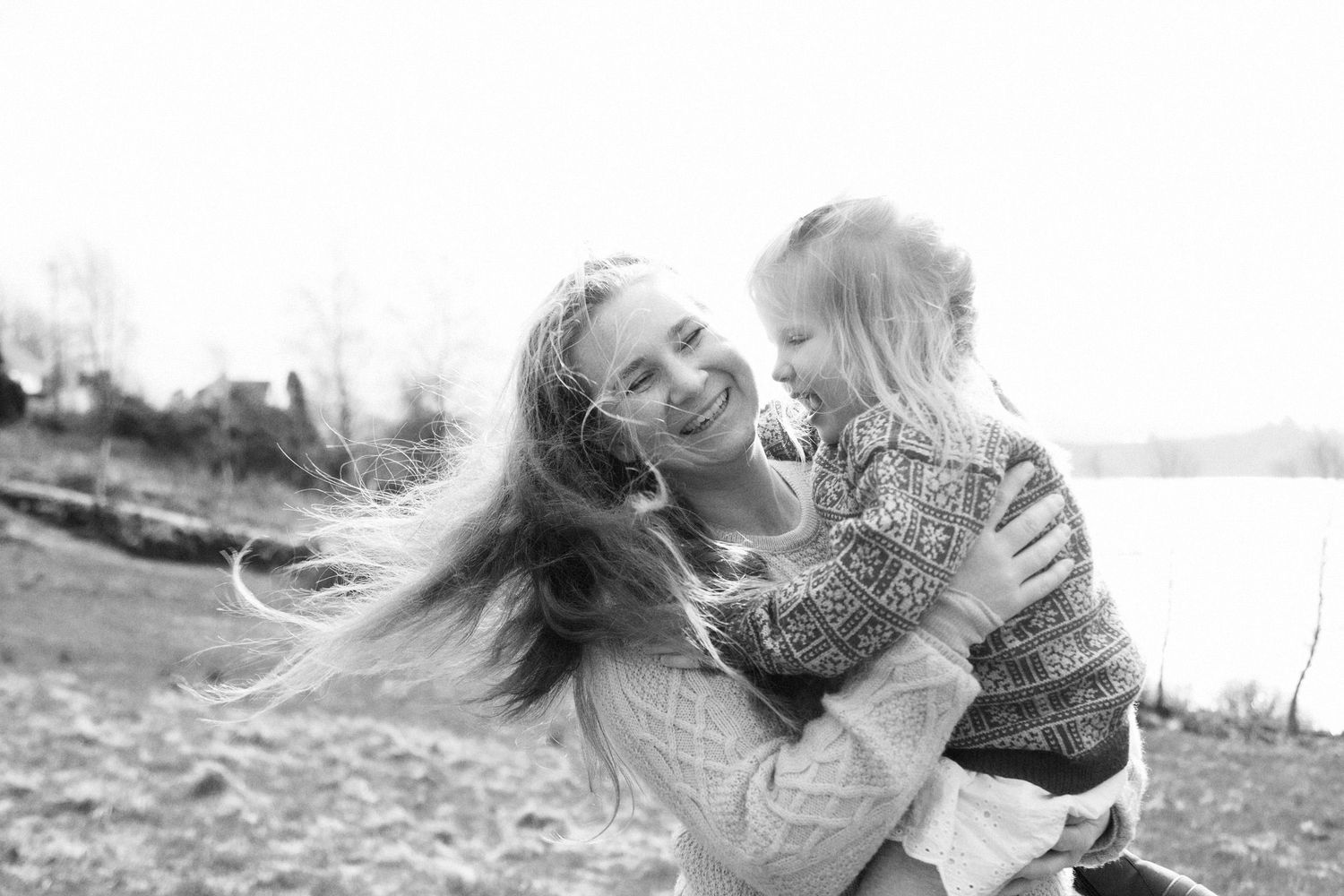 A candid black and white photo capturing a playful spinning moment outdoors.