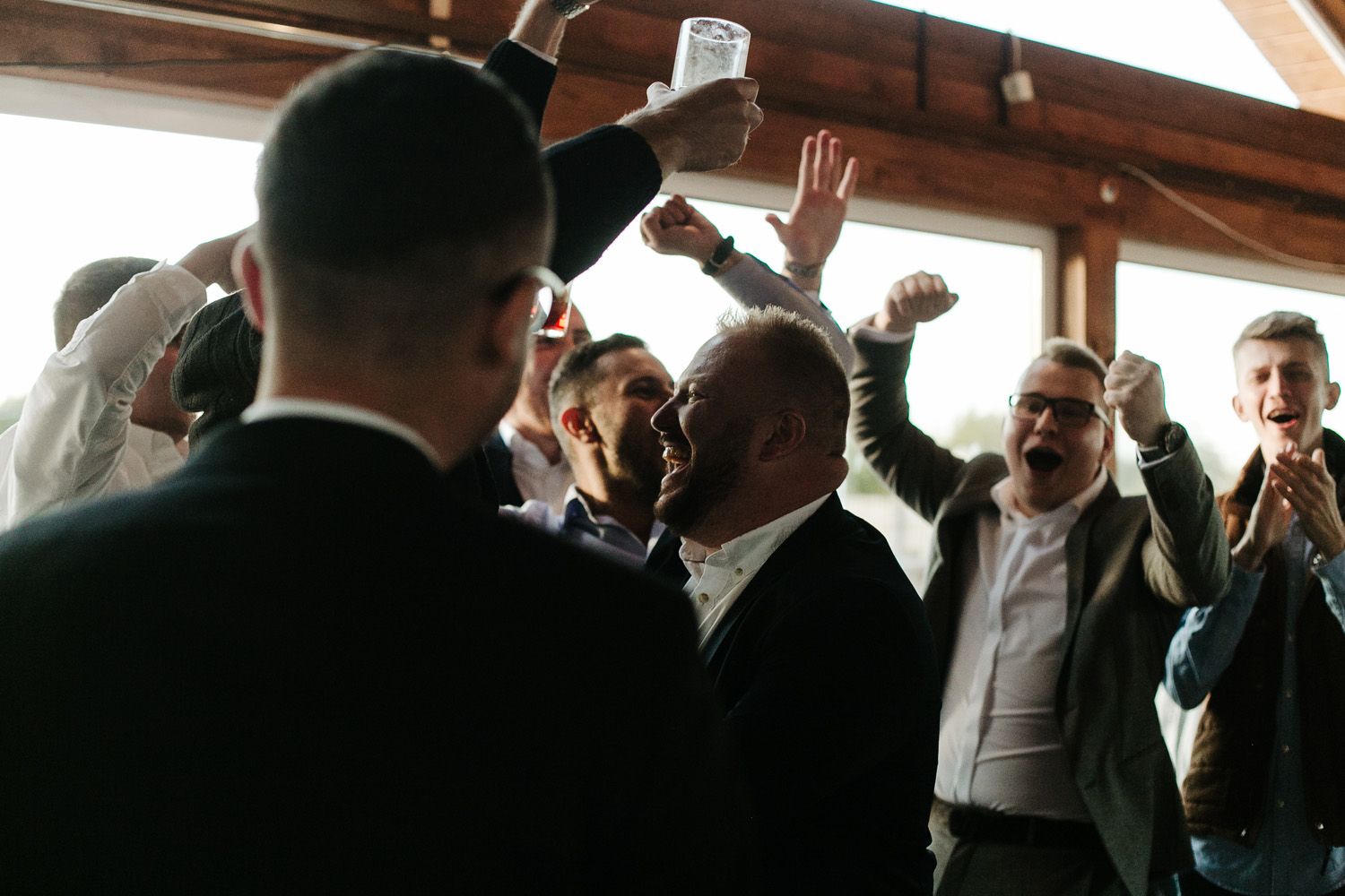 Wedding celebration with guests dancing and enjoying festivities in indoor venue.