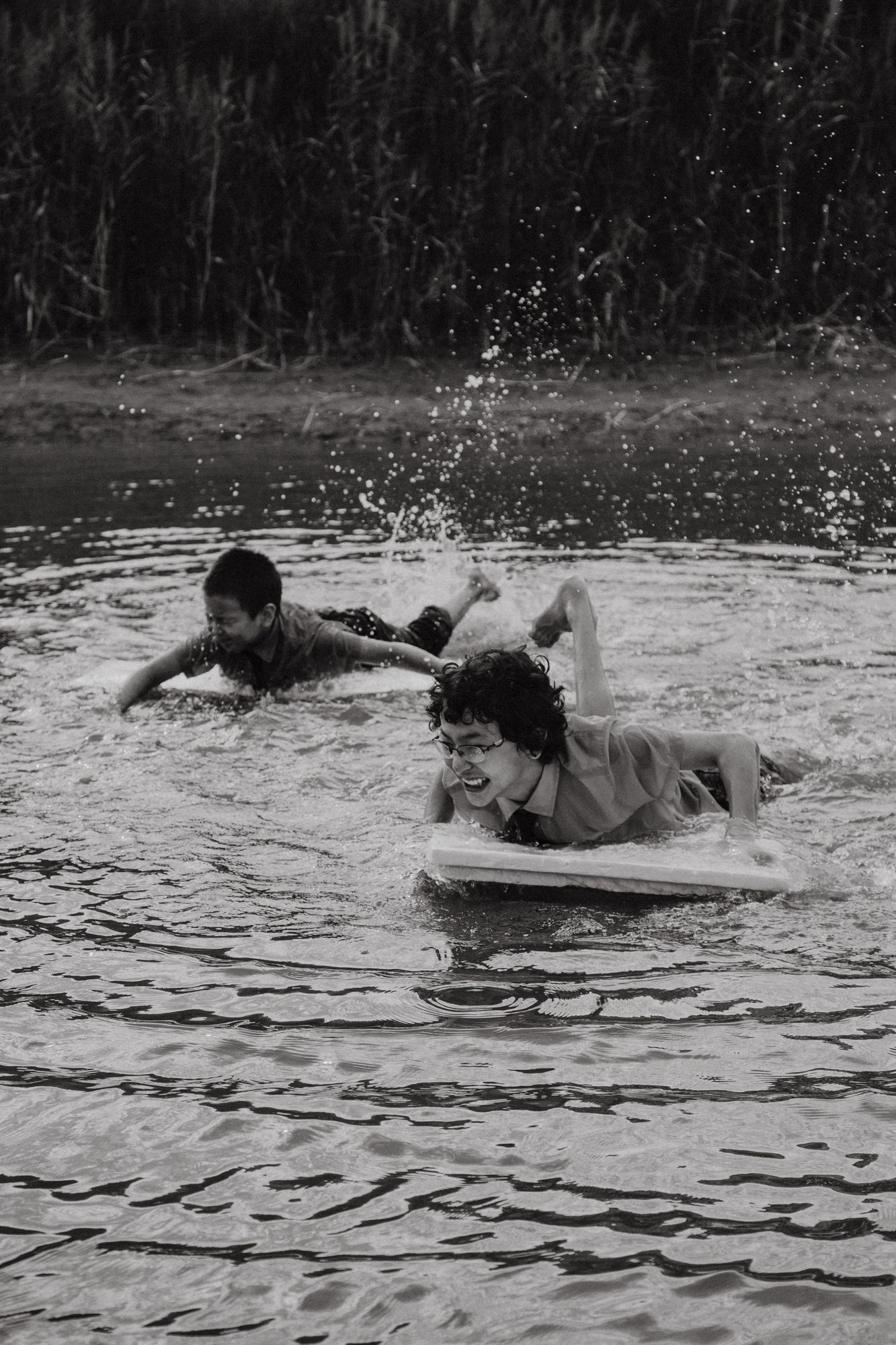 A sequence of black and white photos shows someone falling off a surfboard into rippling water.