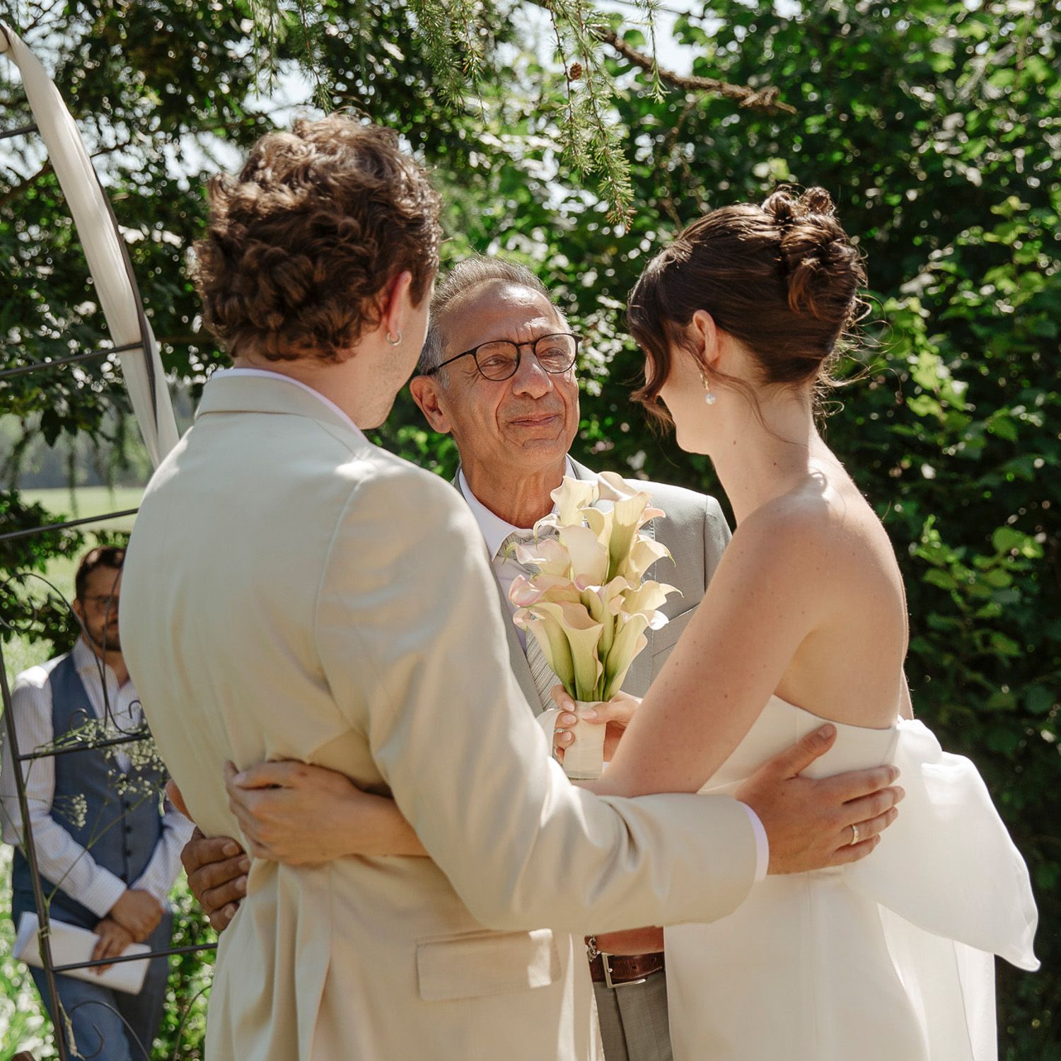 Group of people embracing in an outdoor garden setting during a special celebration.