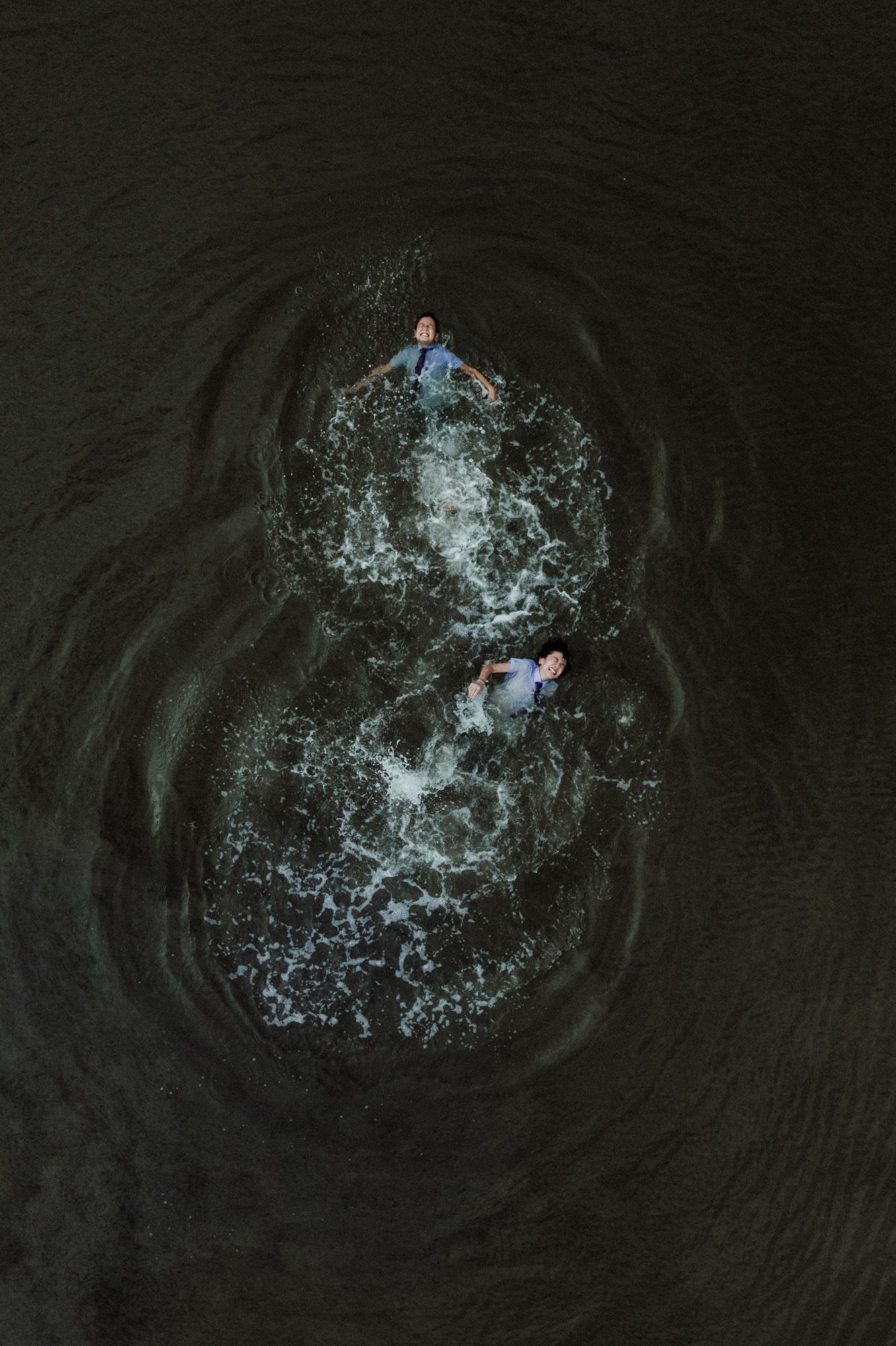 High-speed water droplet impact sequence showing circular ripples and splashes against dark background.