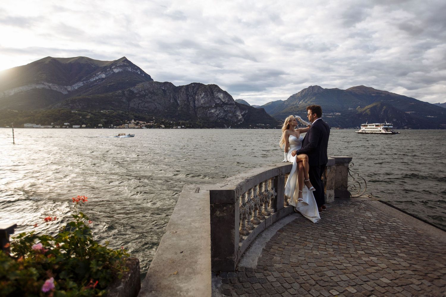 Scenic view of Lake Como in Italy with dramatic cloudy skies and mountains reflecting on the water's surface.