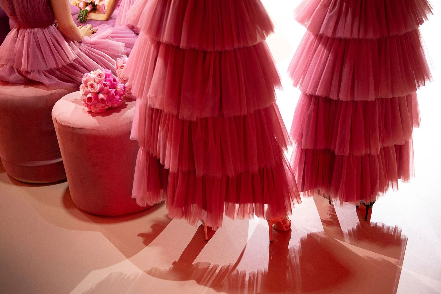 Red tulle ruffled dresses displayed in a fashion boutique setting with soft lighting and romantic ambiance.