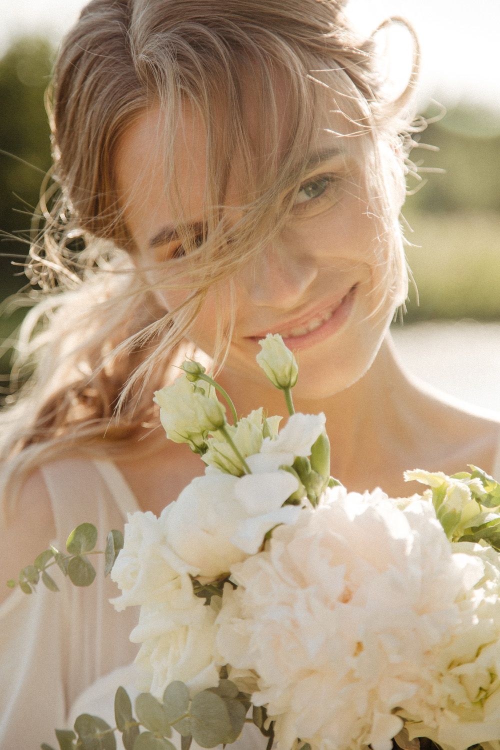Close-up of white bouquet with delicate flowers against soft natural lighting.
