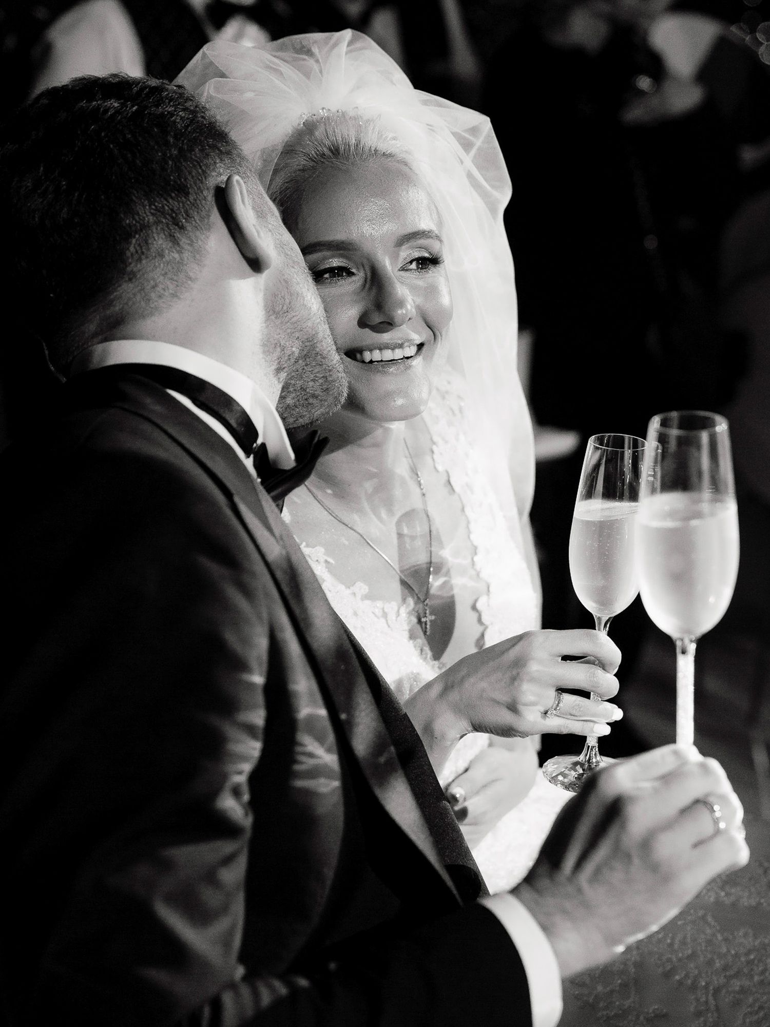 A series of black and white wedding photos showing intimate moments between newlyweds sharing champagne toasts.