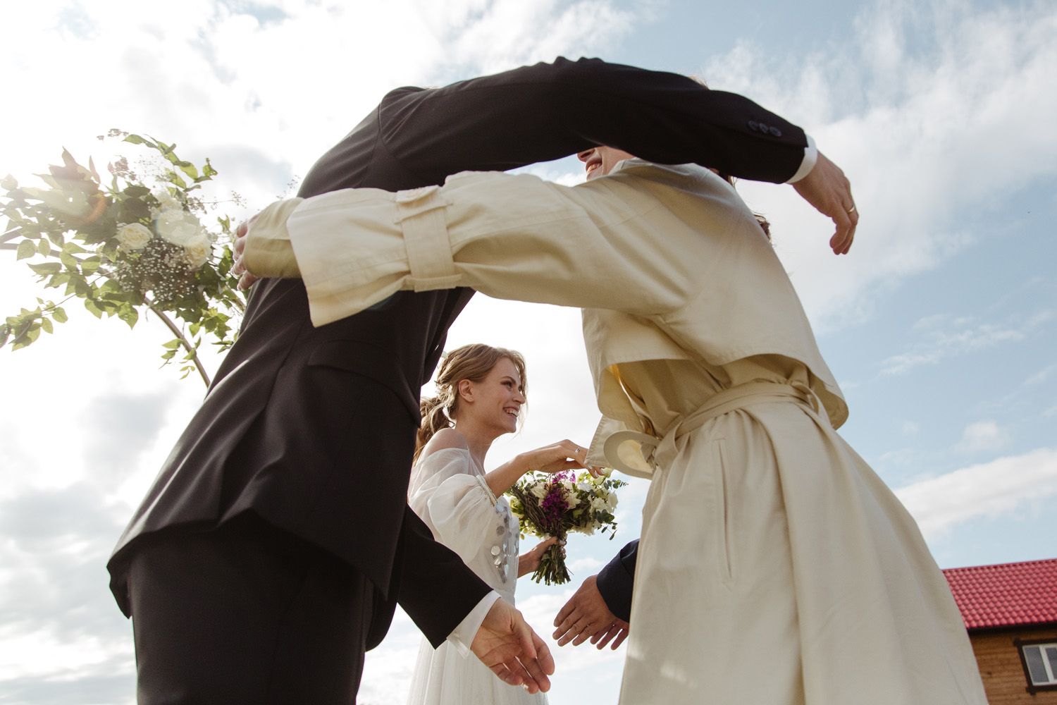 Couple celebrating during their outdoor wedding ceremony with white floral accents.