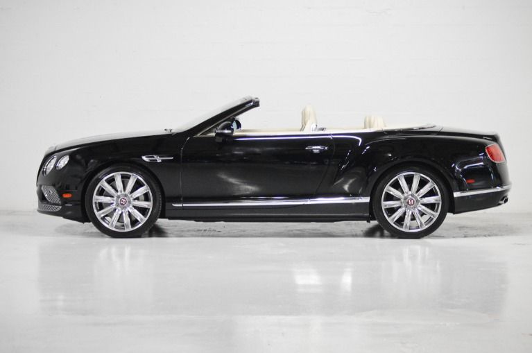 Black Bentley Continental GT convertible with top down, showcasing chrome wheels on a clean white background.