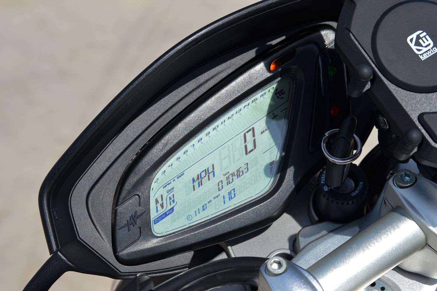 Close-up of a motorcycle digital dashboard displaying MPH speedometer and instrument cluster gauges.