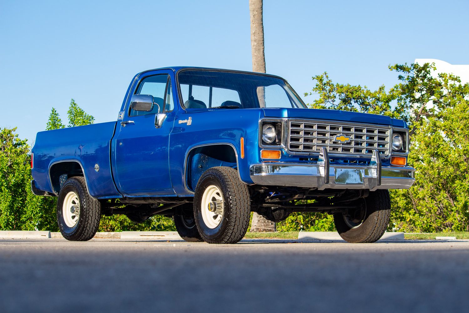 Blue 1970s Chevrolet C/K pickup truck 4x4 parked outdoors, front three-quarter view showing classic square body styling.