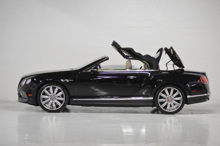 Black Bentley Continental GTC convertible with top down, side profile view, showcasing luxury design on white background.