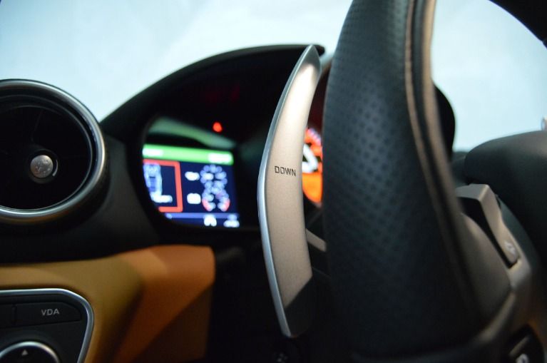 Close-up of a digital instrument cluster display with orange ambient lighting.