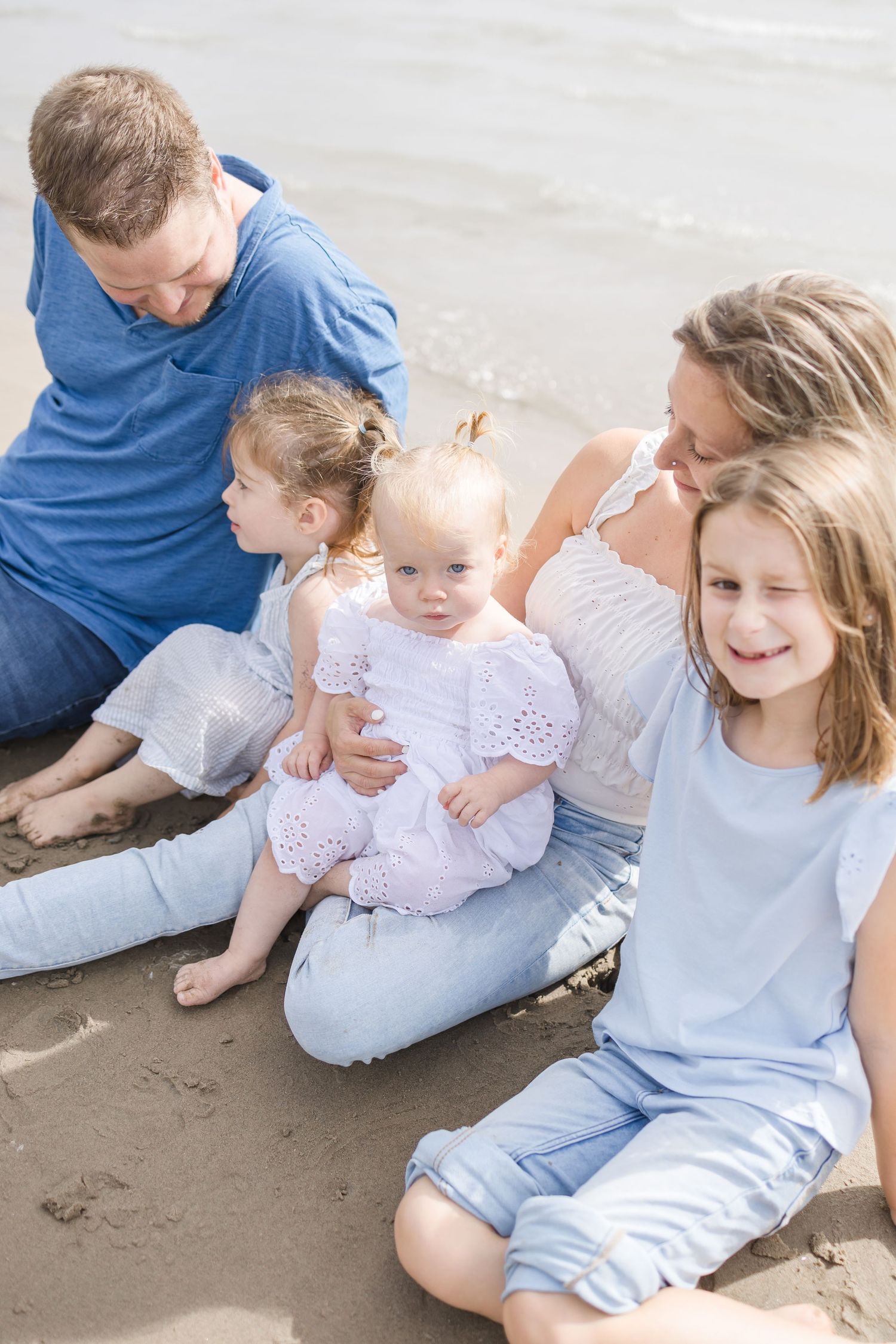 Family spending time together on a peaceful beach during an overcast day.