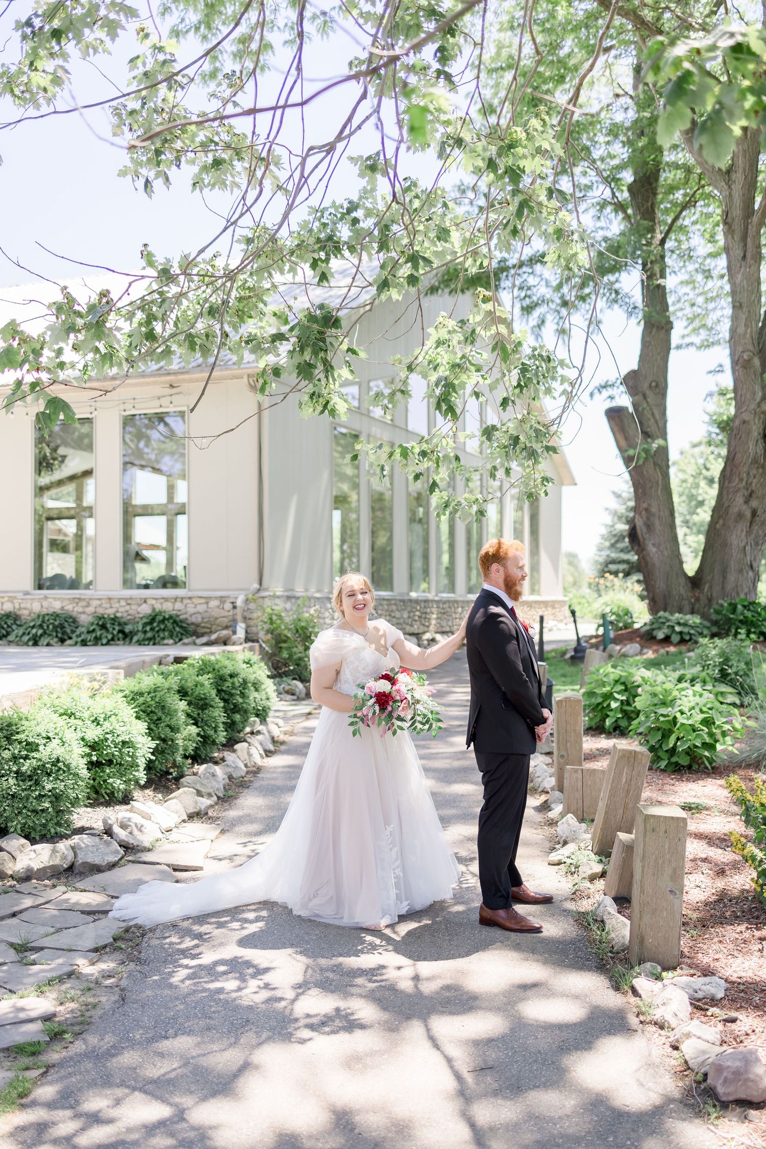 Wedding ceremony location with stone pillars and lush greenery in natural lighting.
