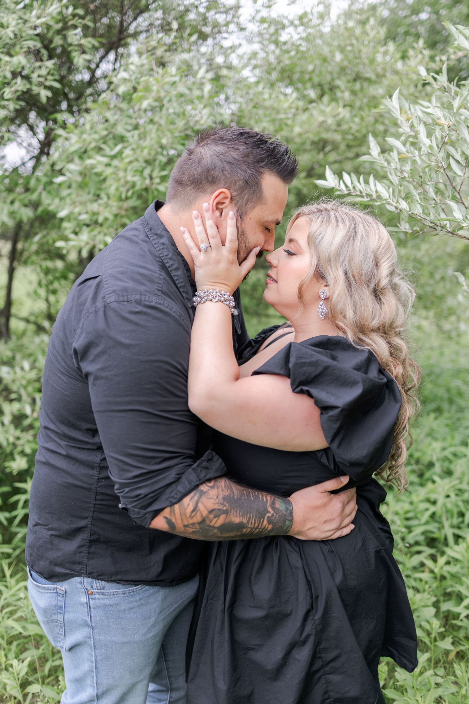 An intimate moment shared between two people surrounded by greenery.