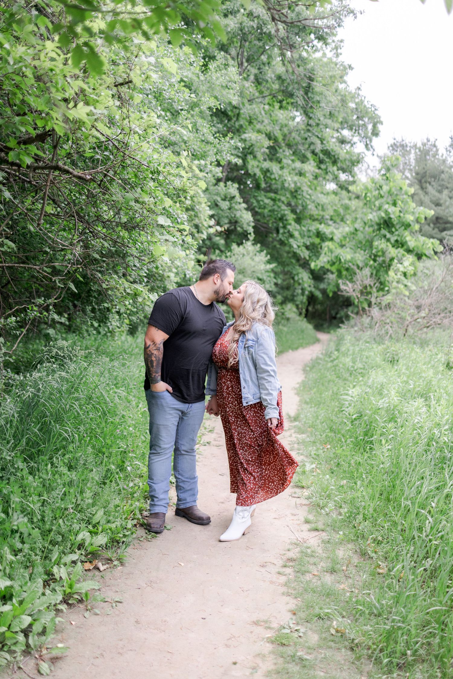 Intimate moment captured between two people on a winding forest path.